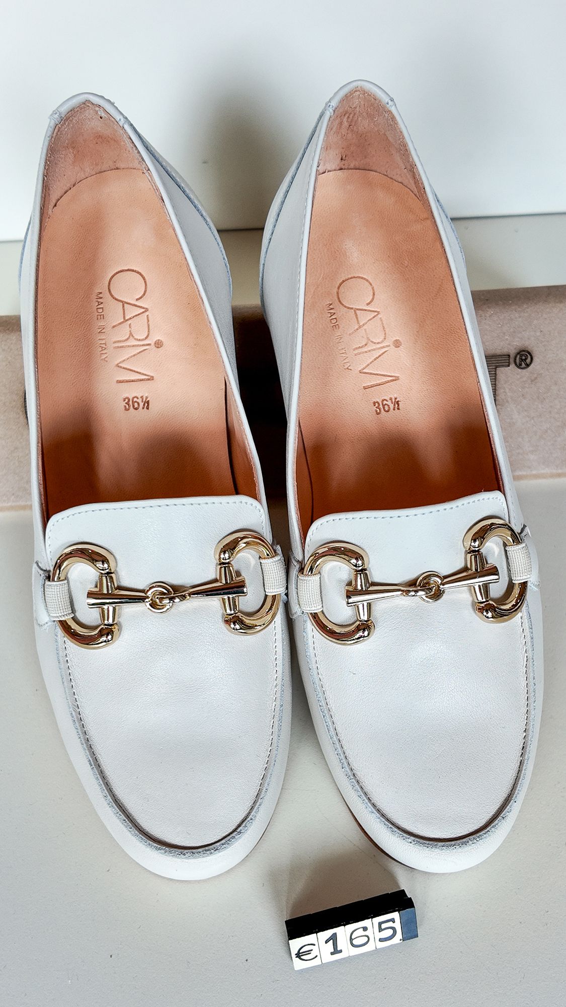 Mocassini in pelle bianca con dettaglio a morsetto dorato.