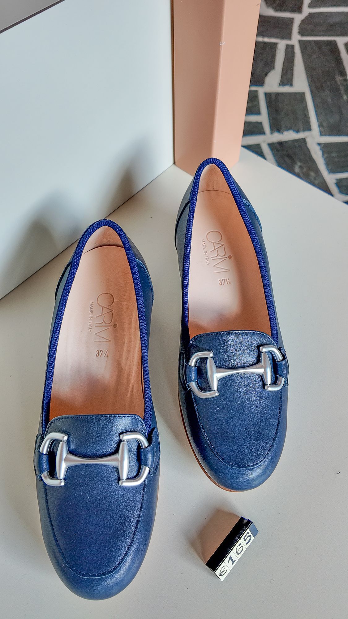 Mocassini blu glitterati con dettagli argentati, esposti su una superficie chiara.