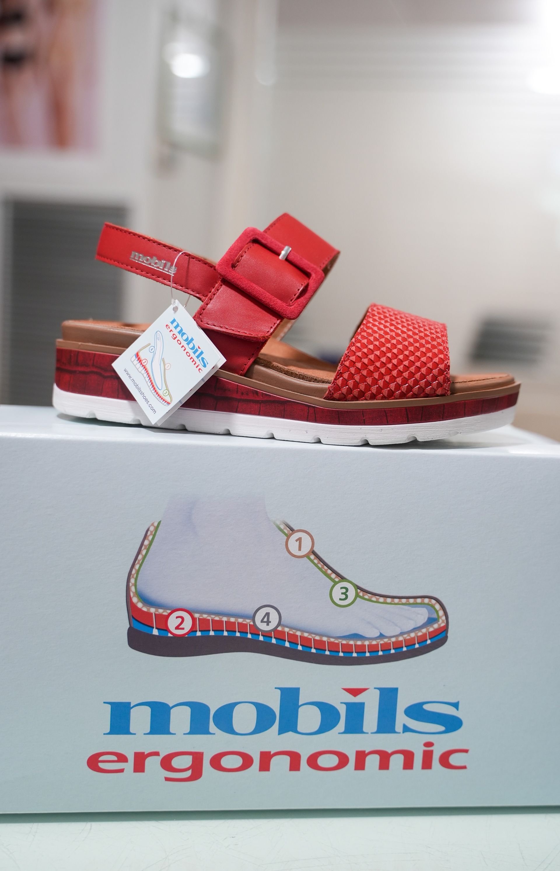 Sandalo rosso su scatola con logo 