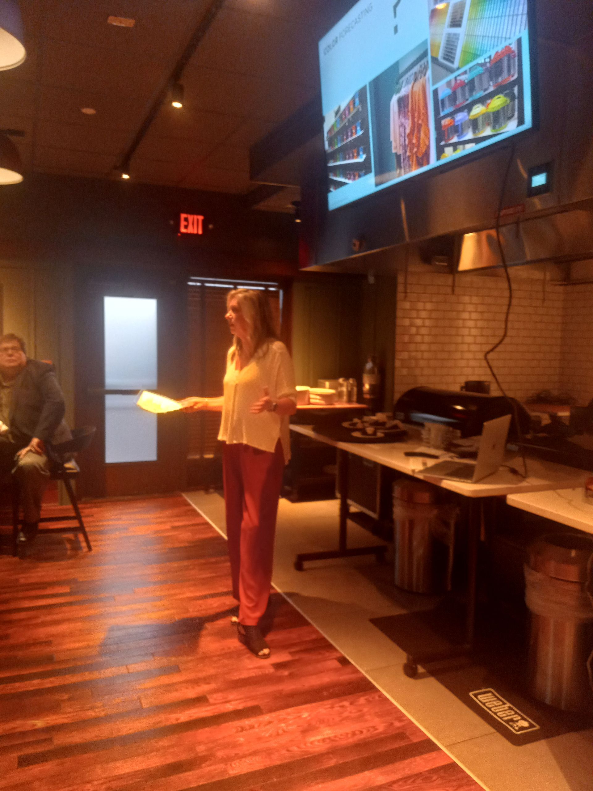 A woman is standing in a room holding a piece of paper.