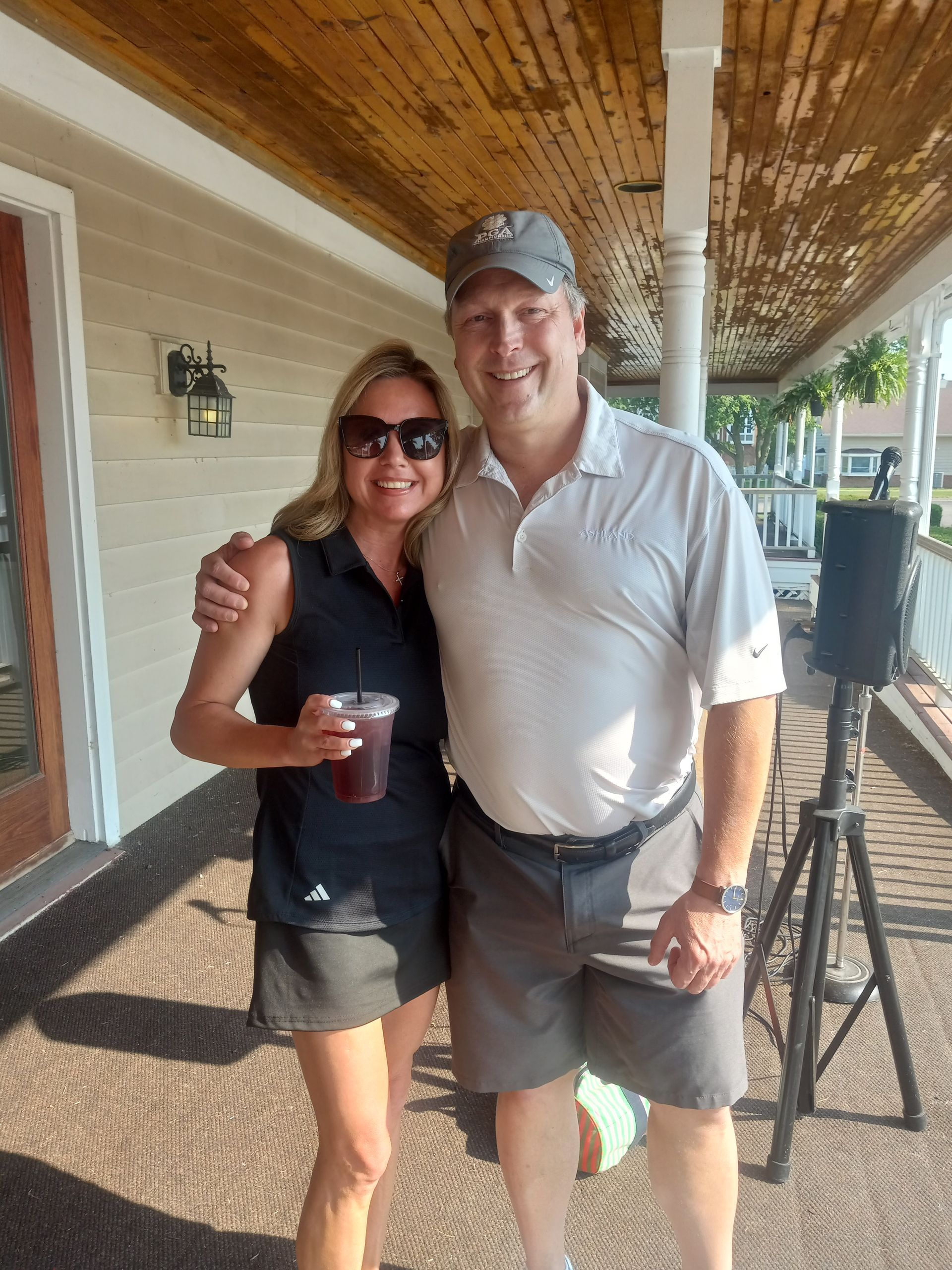 A man and a woman are posing for a picture on a porch.
