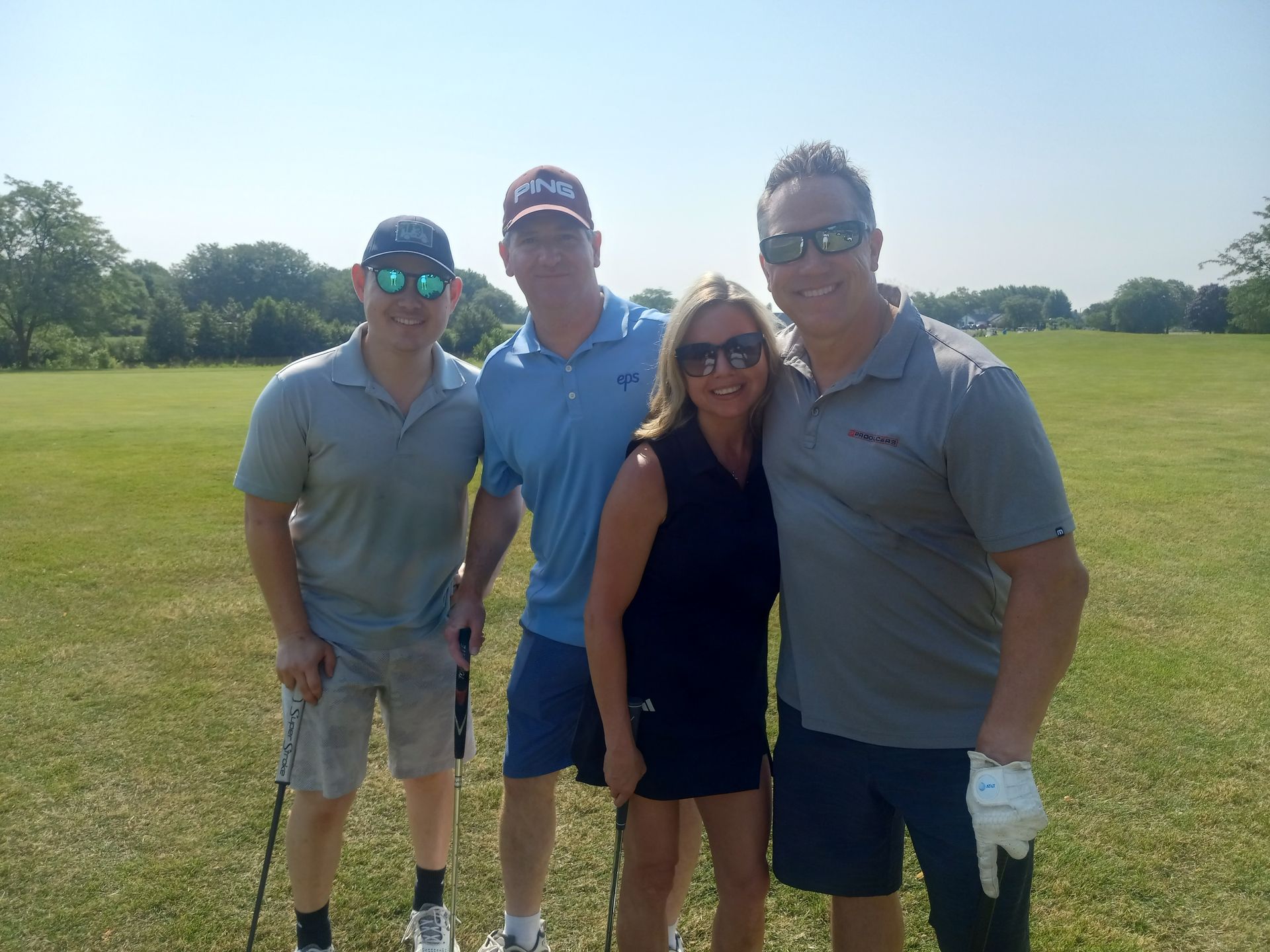 A group of people posing for a picture on a golf course