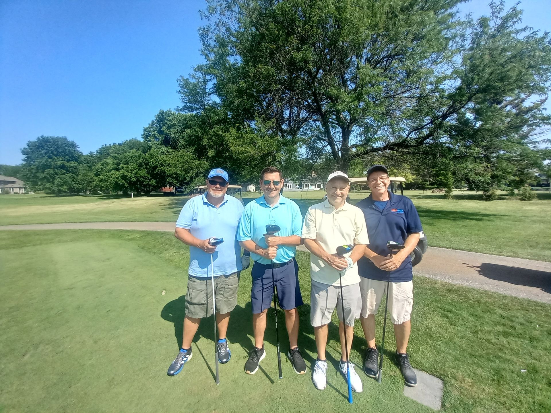 A group of men are posing for a picture on a golf course.