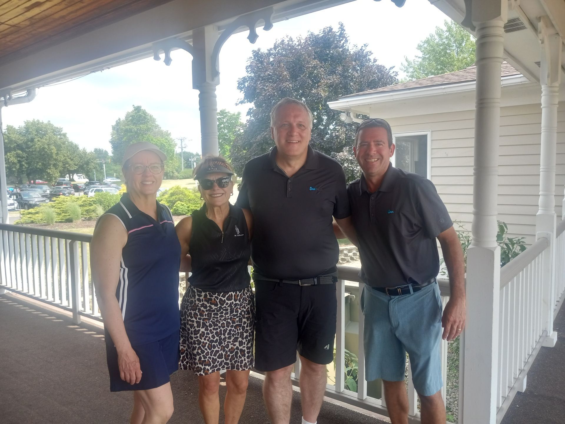 A group of people are posing for a picture on a porch.