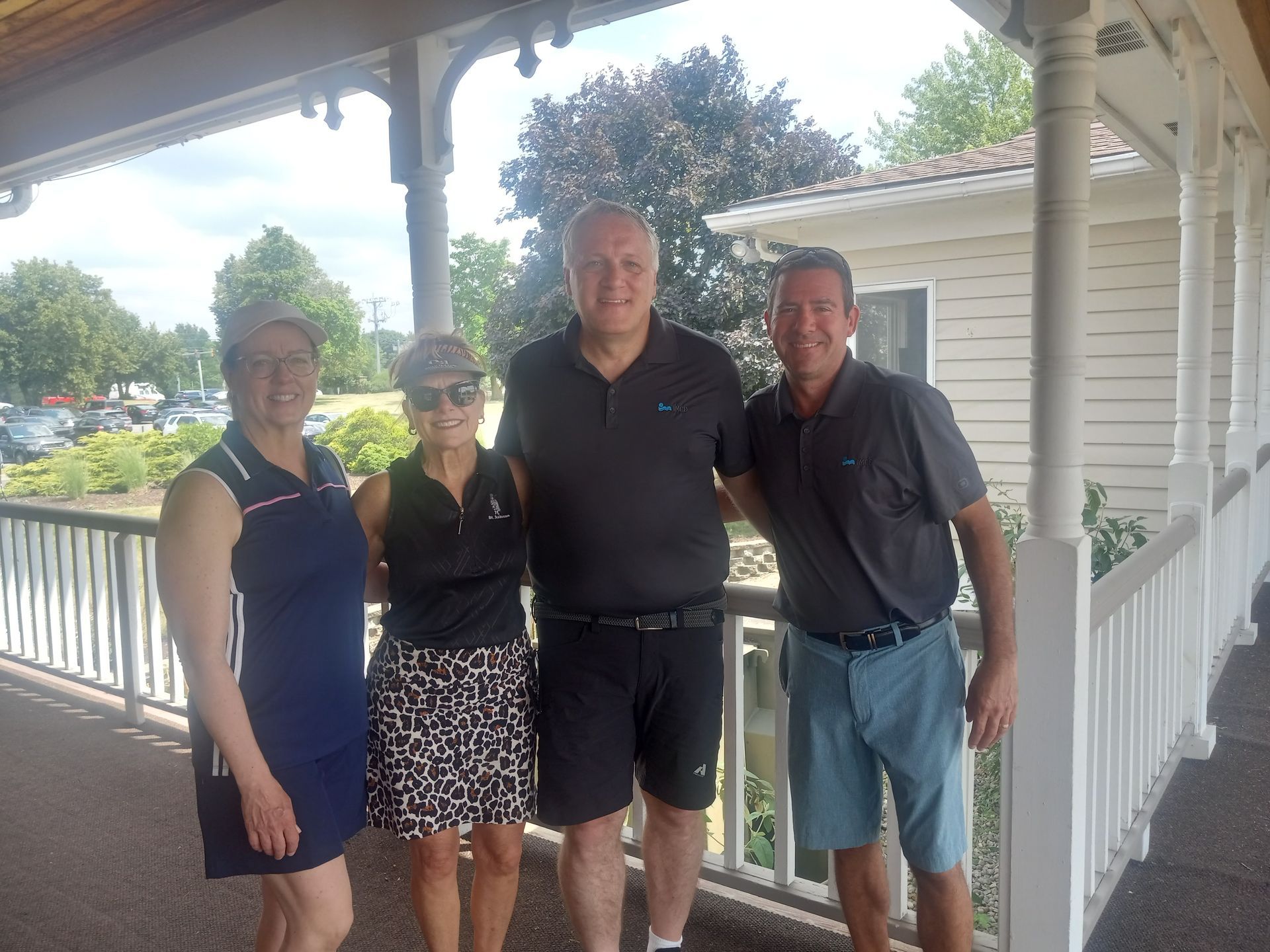 A group of people are posing for a picture on a porch.