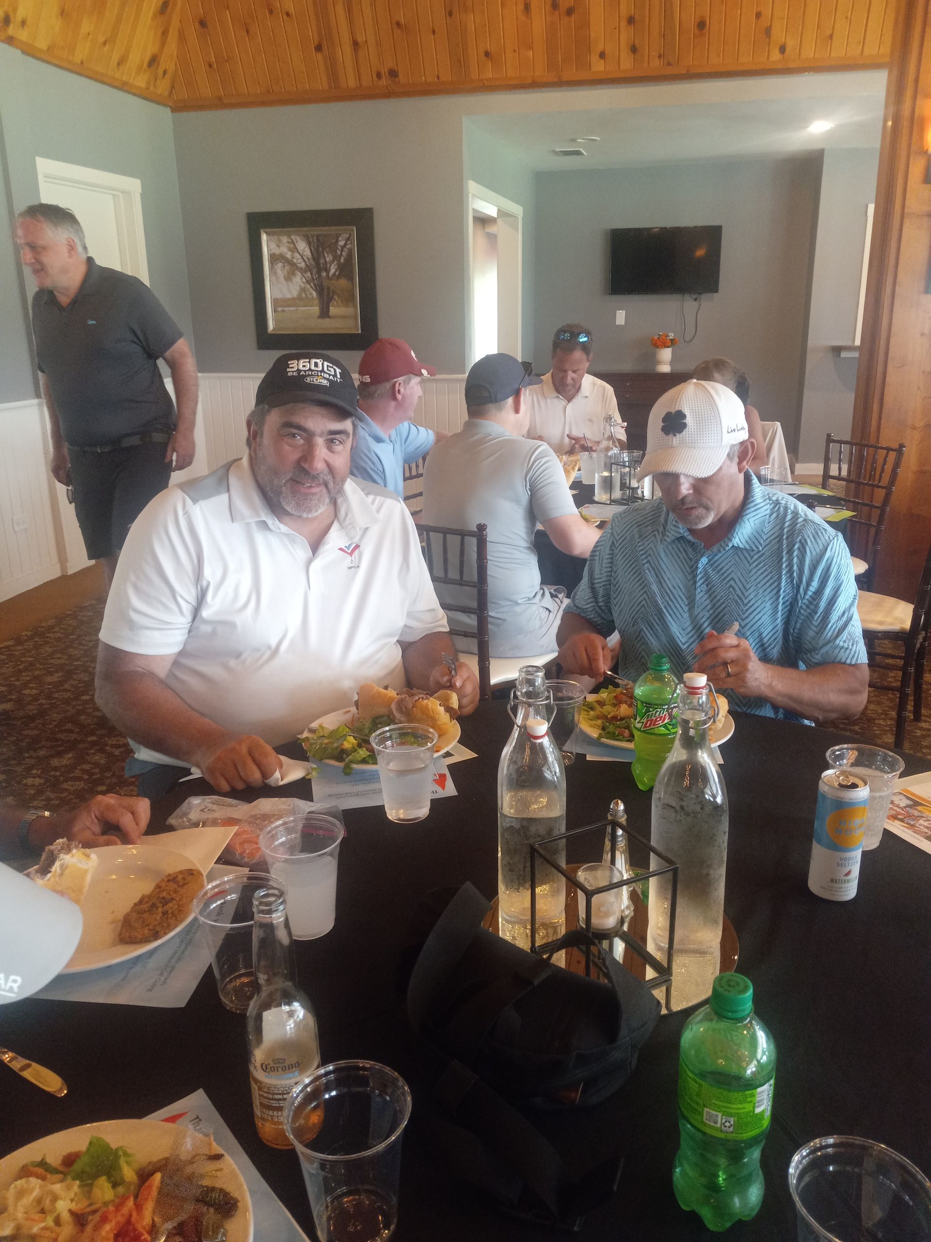 A group of men are sitting at a table eating food.
