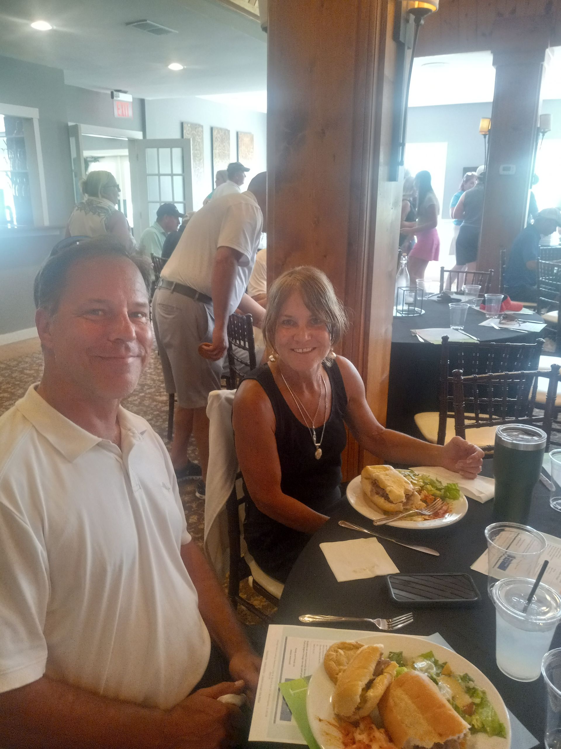 A man and a woman are sitting at a table with plates of food.