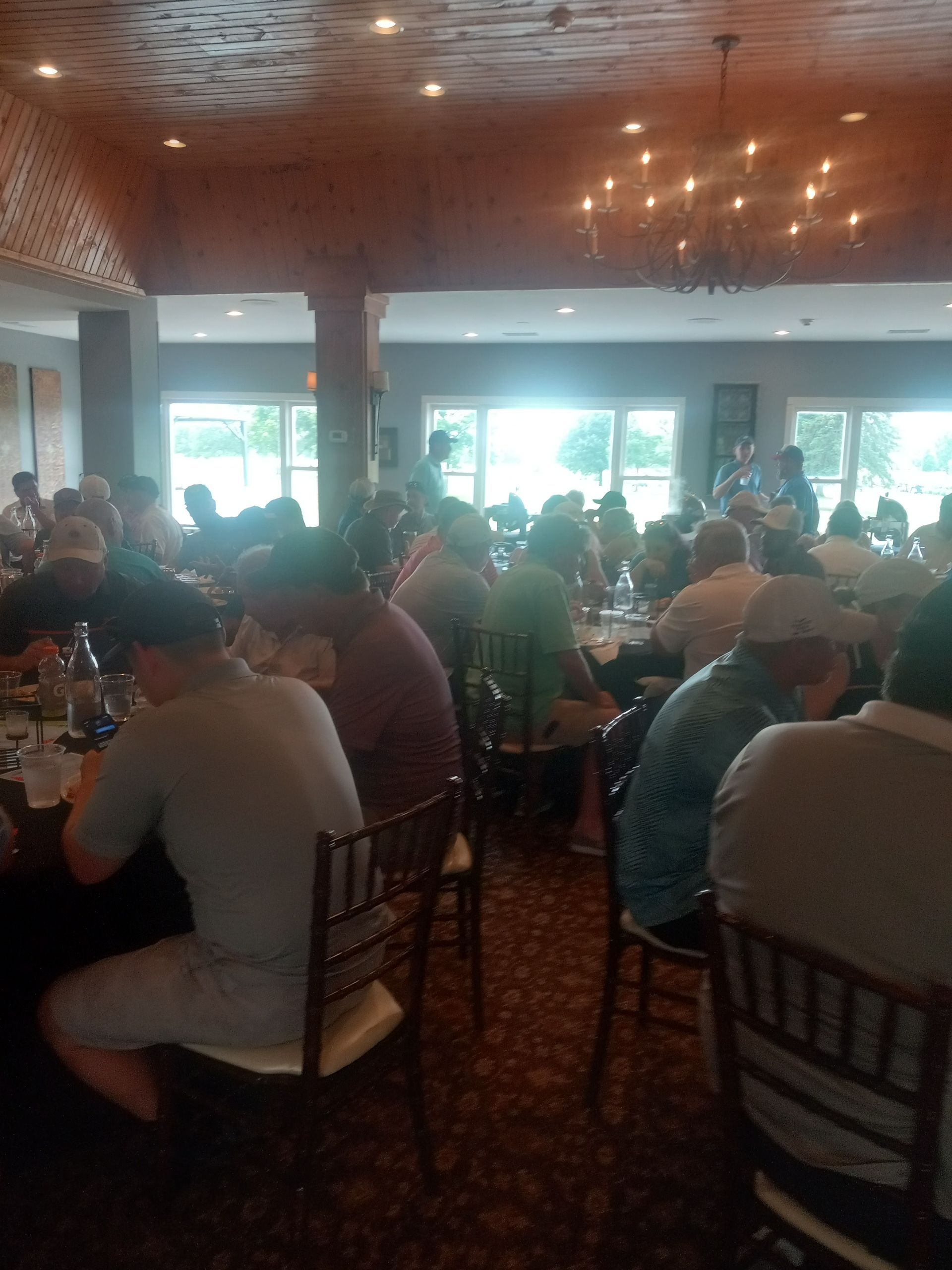 A large group of people are sitting at tables in a restaurant.