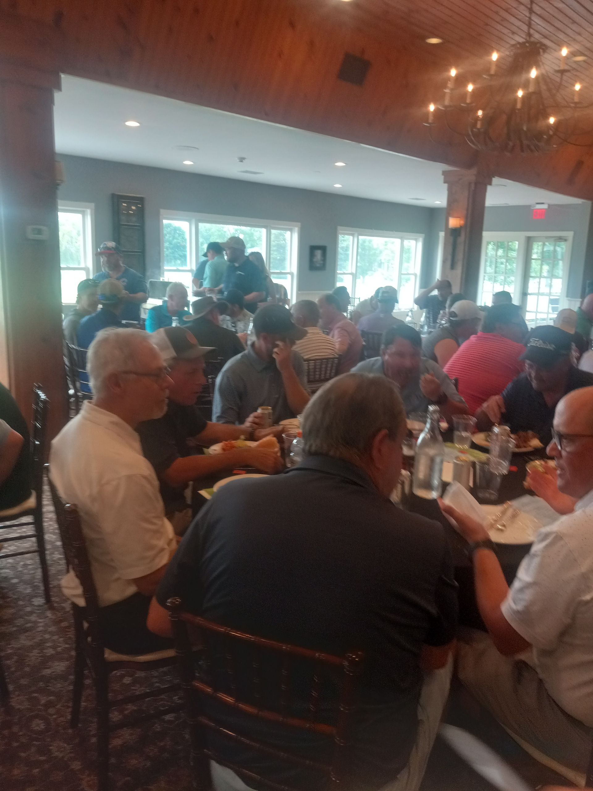 A group of people are sitting at tables in a restaurant.