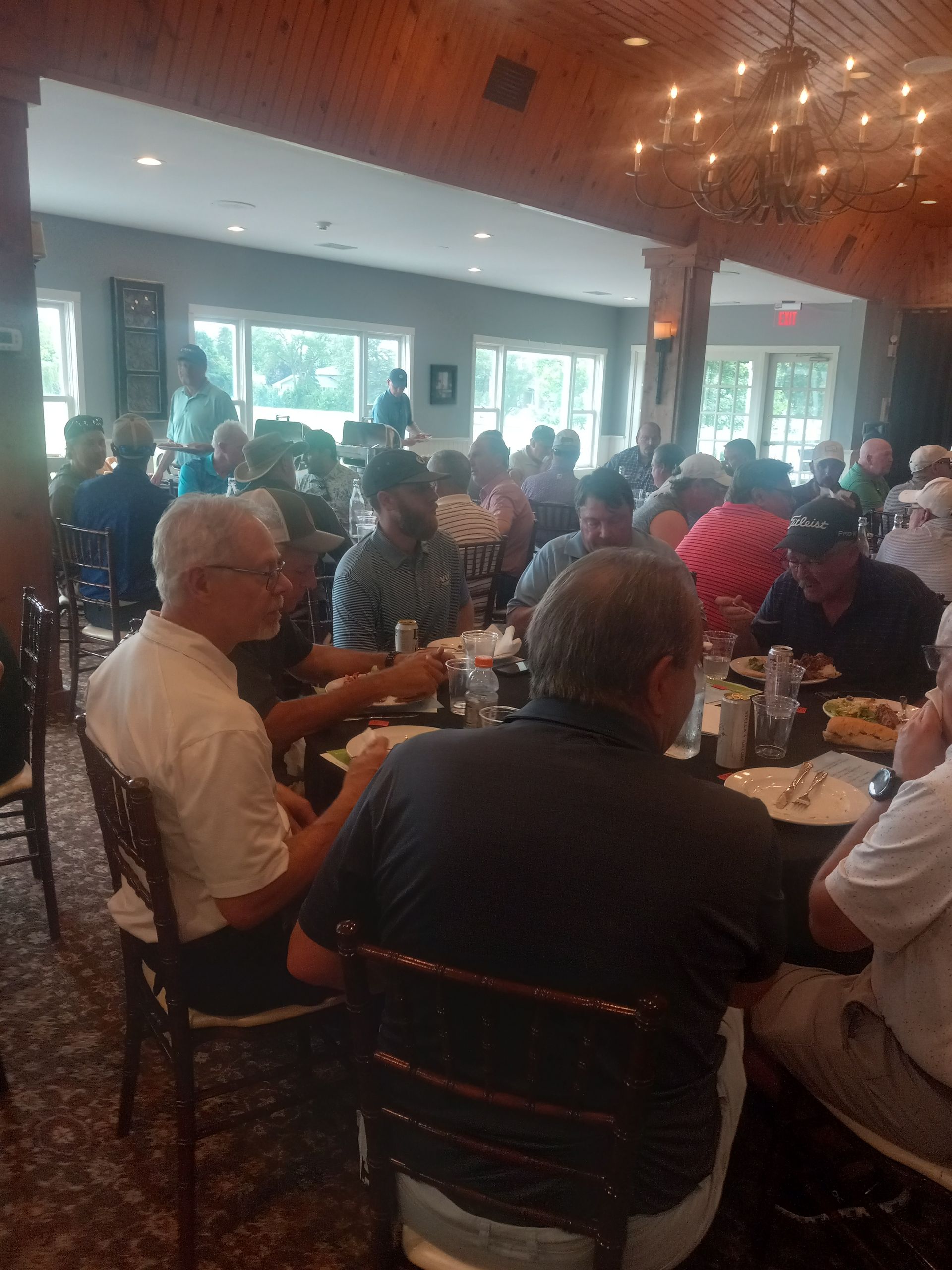 A group of people are sitting at tables in a restaurant.