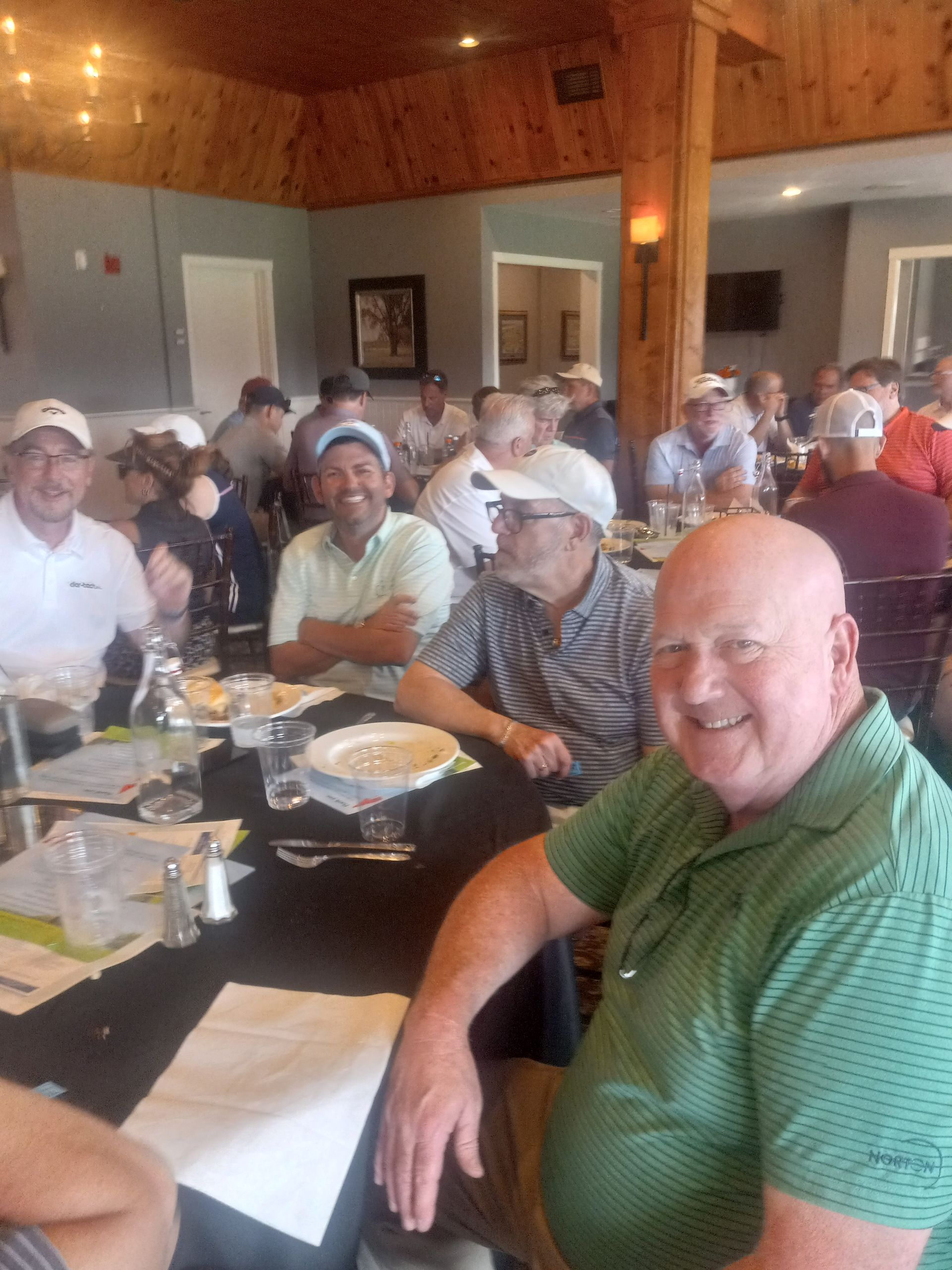 A group of men are sitting at tables in a restaurant.