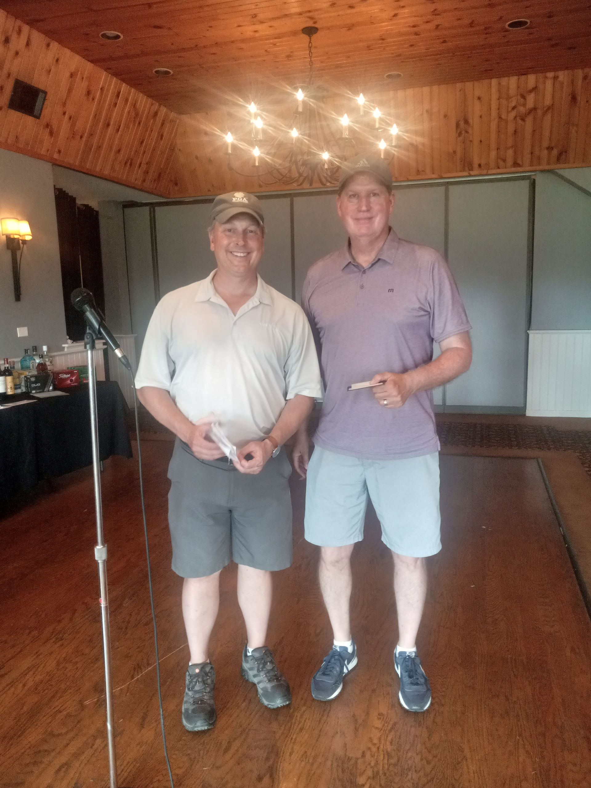 Two men standing next to each other in front of a microphone