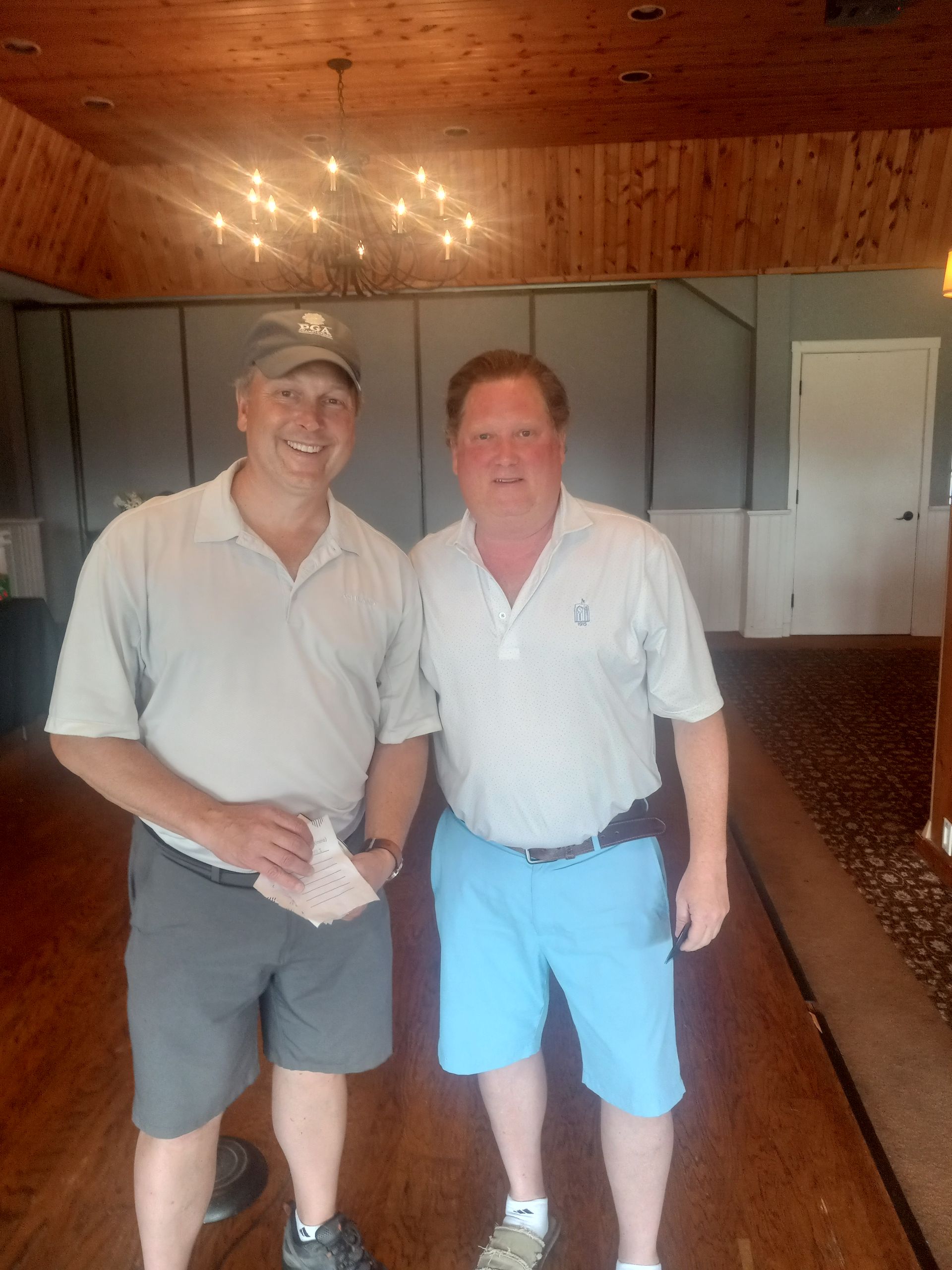 Two men are standing next to each other in a room.