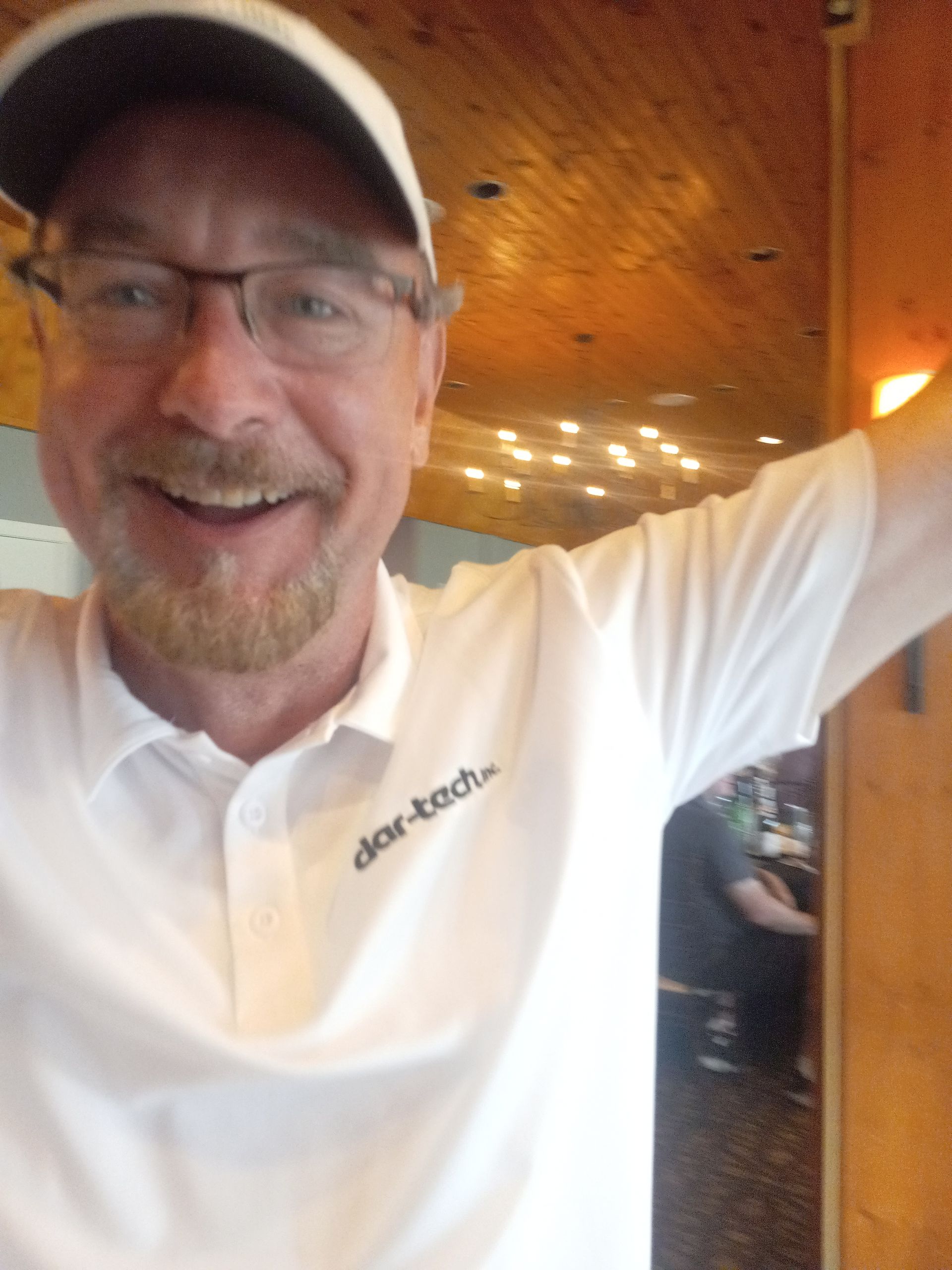 A man wearing a white shirt with the word tech on it