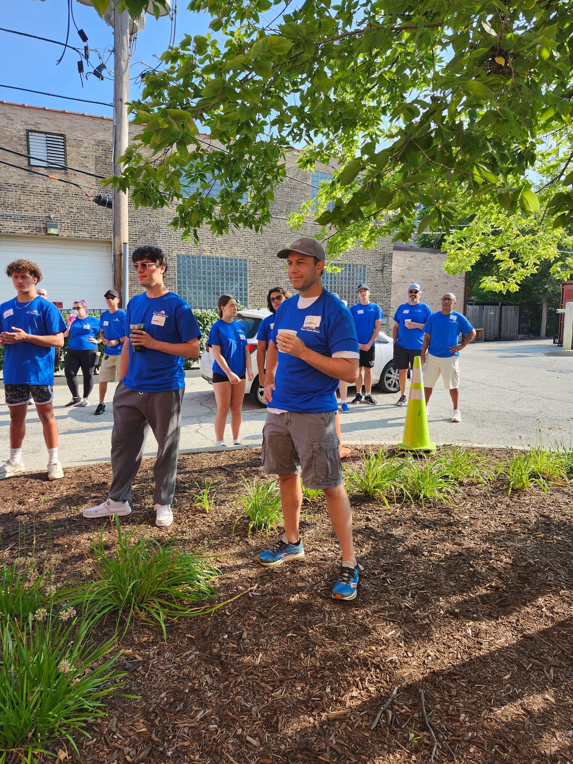 A man in a blue shirt is standing in front of a group of people.