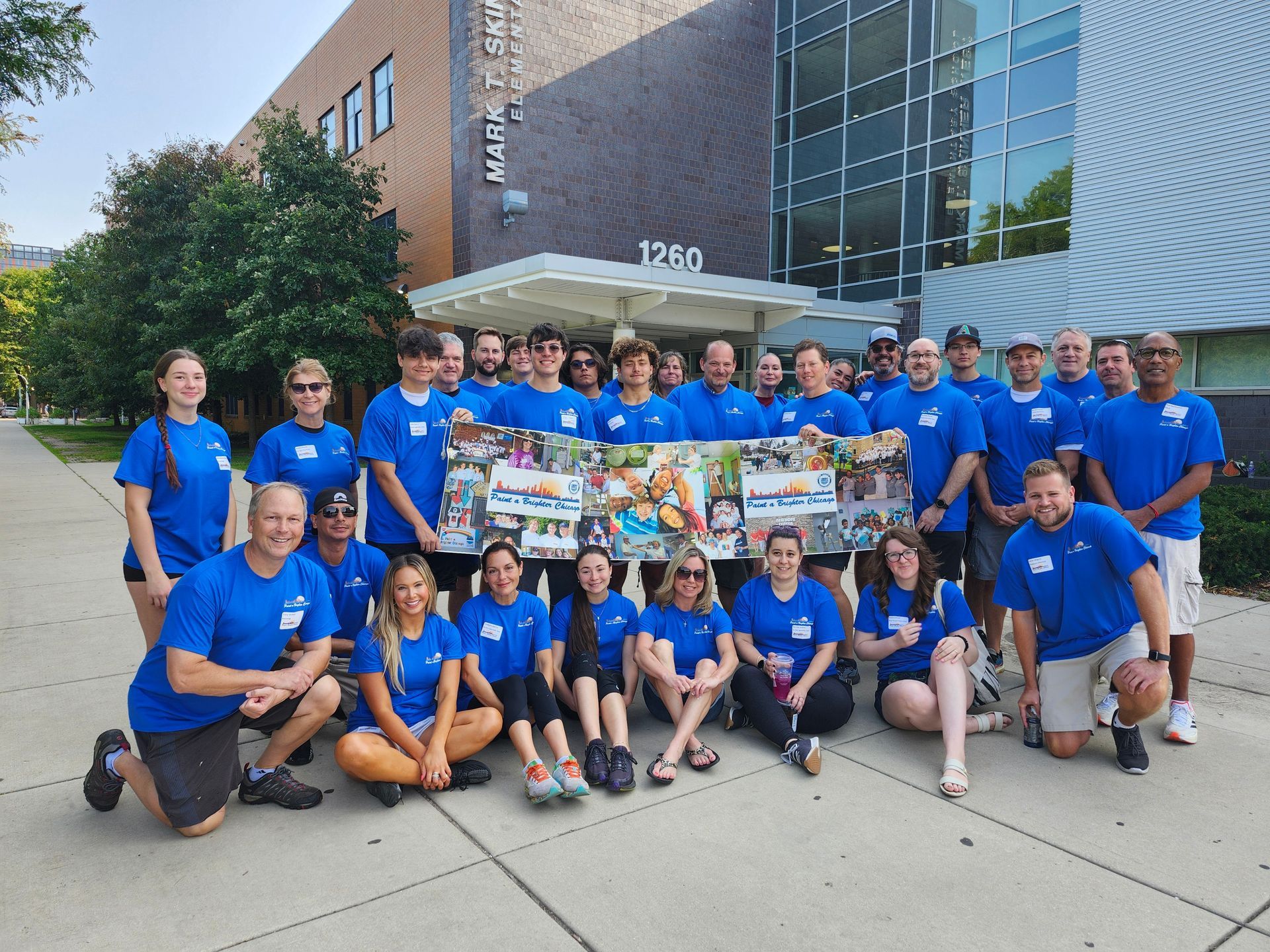 A group of people in blue shirts are posing for a picture