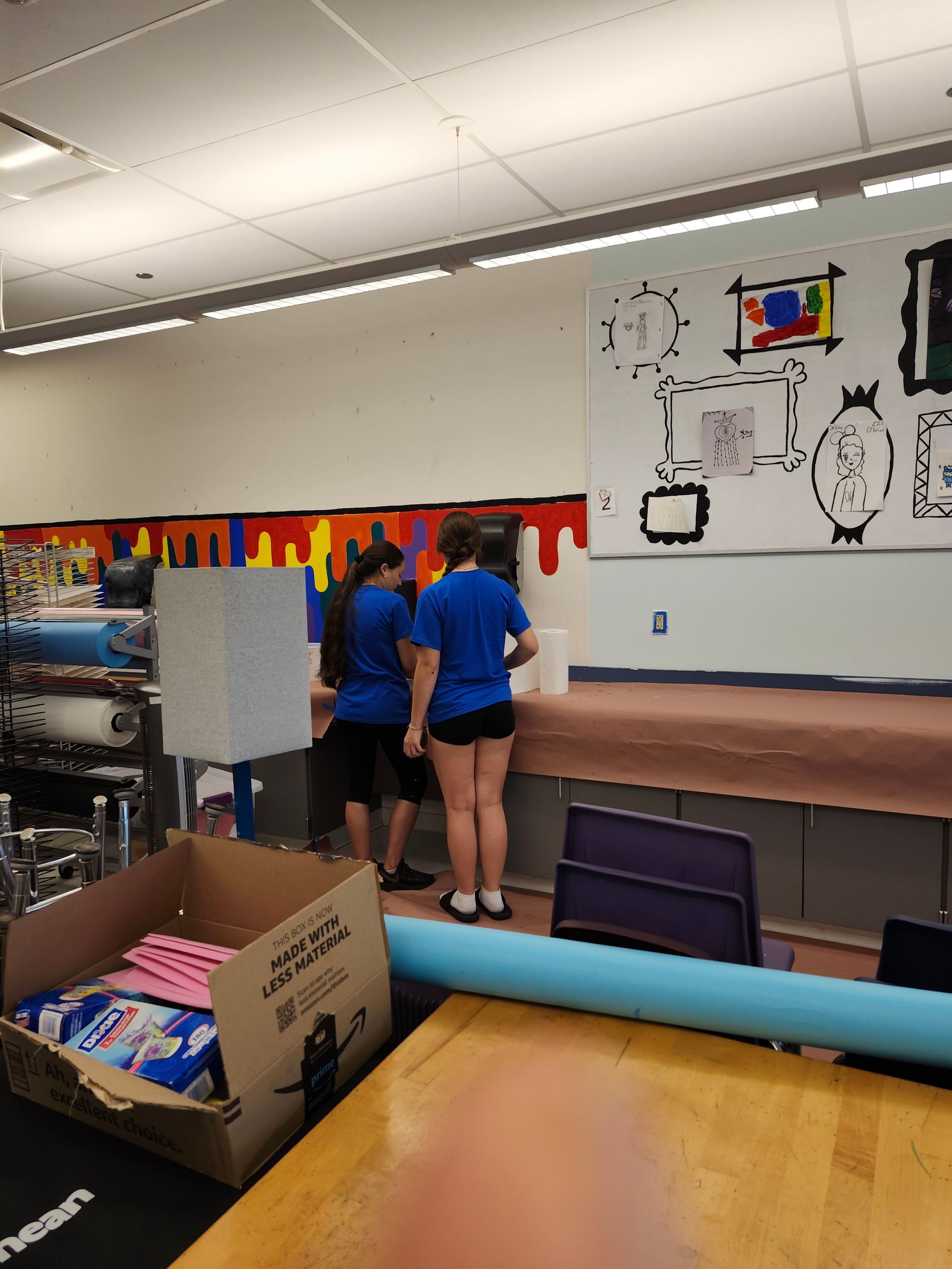 A group of people are standing in front of a wall that says 