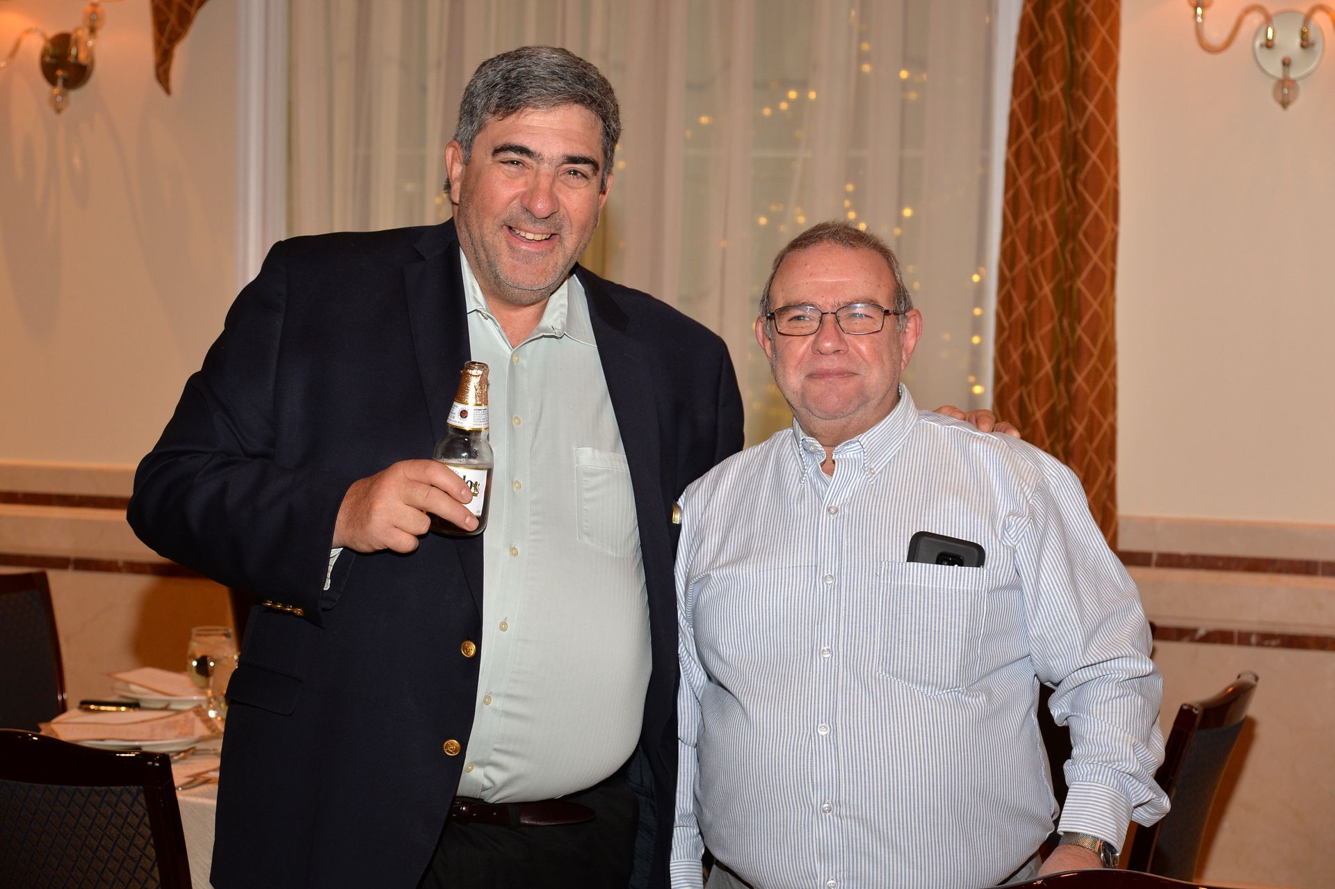 Two men are posing for a picture in a restaurant.