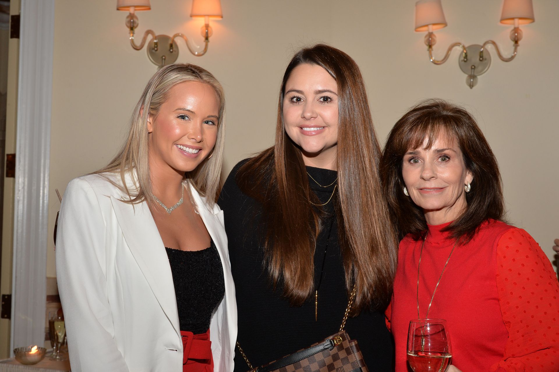 Three women are posing for a picture together in a room.