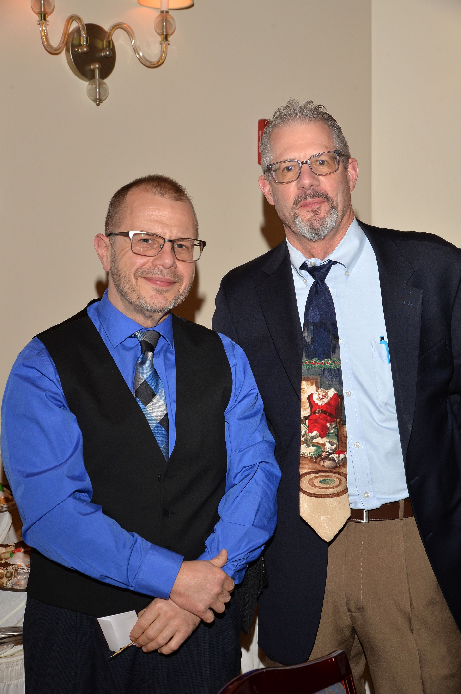 Two men in suits and ties are posing for a picture