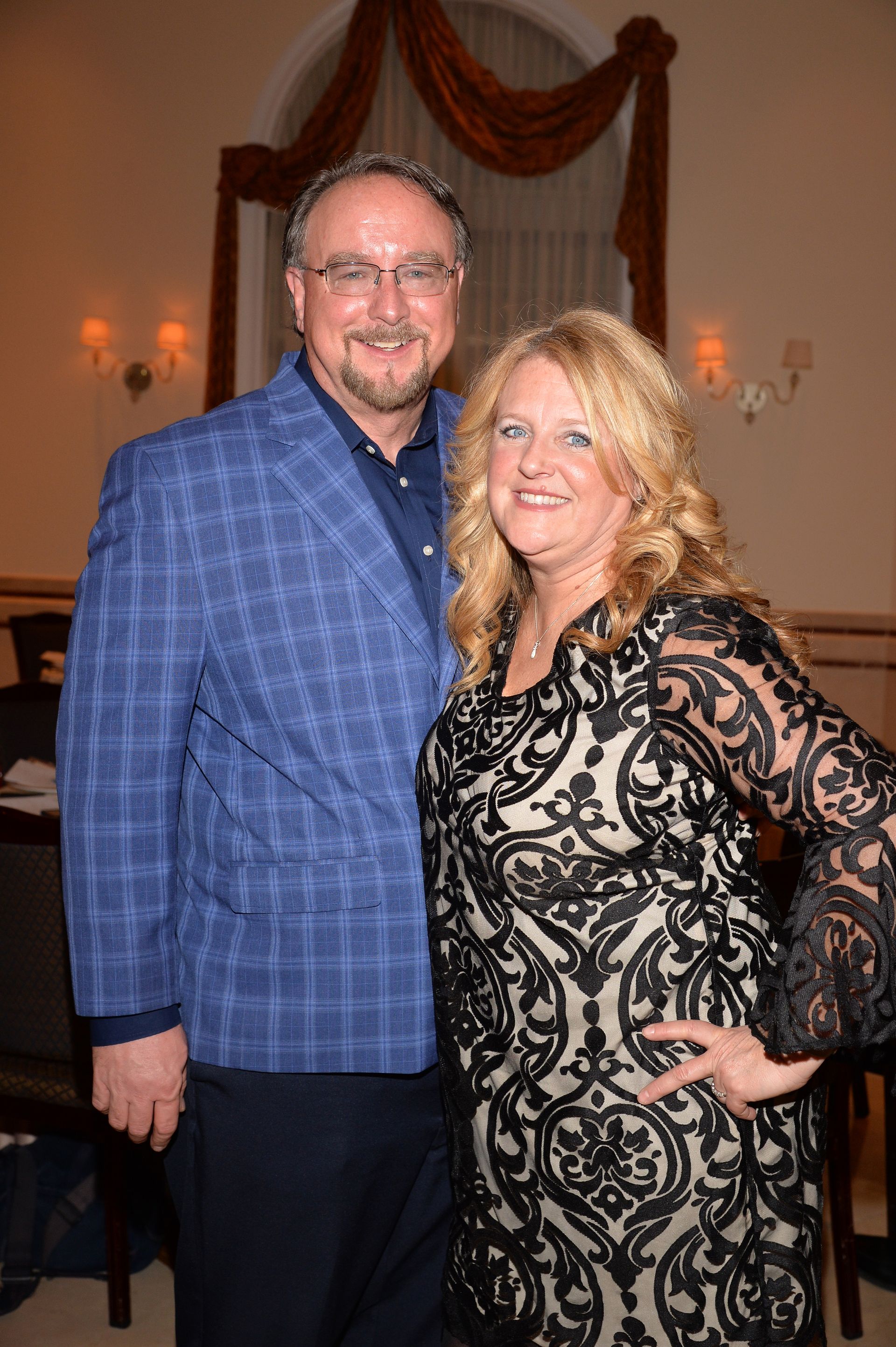 A man and a woman are posing for a picture in a room.