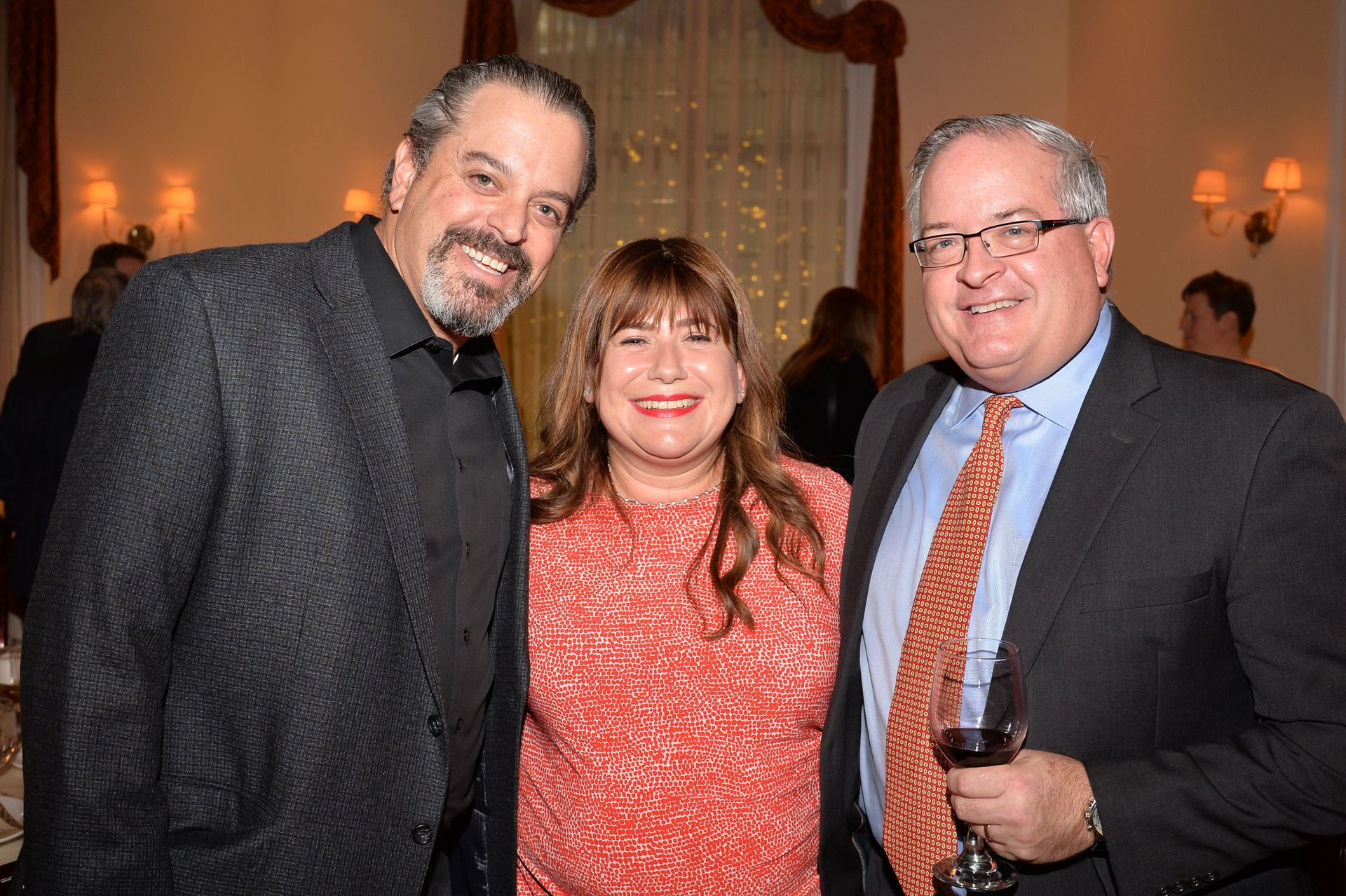 Three people are posing for a picture together in a room.