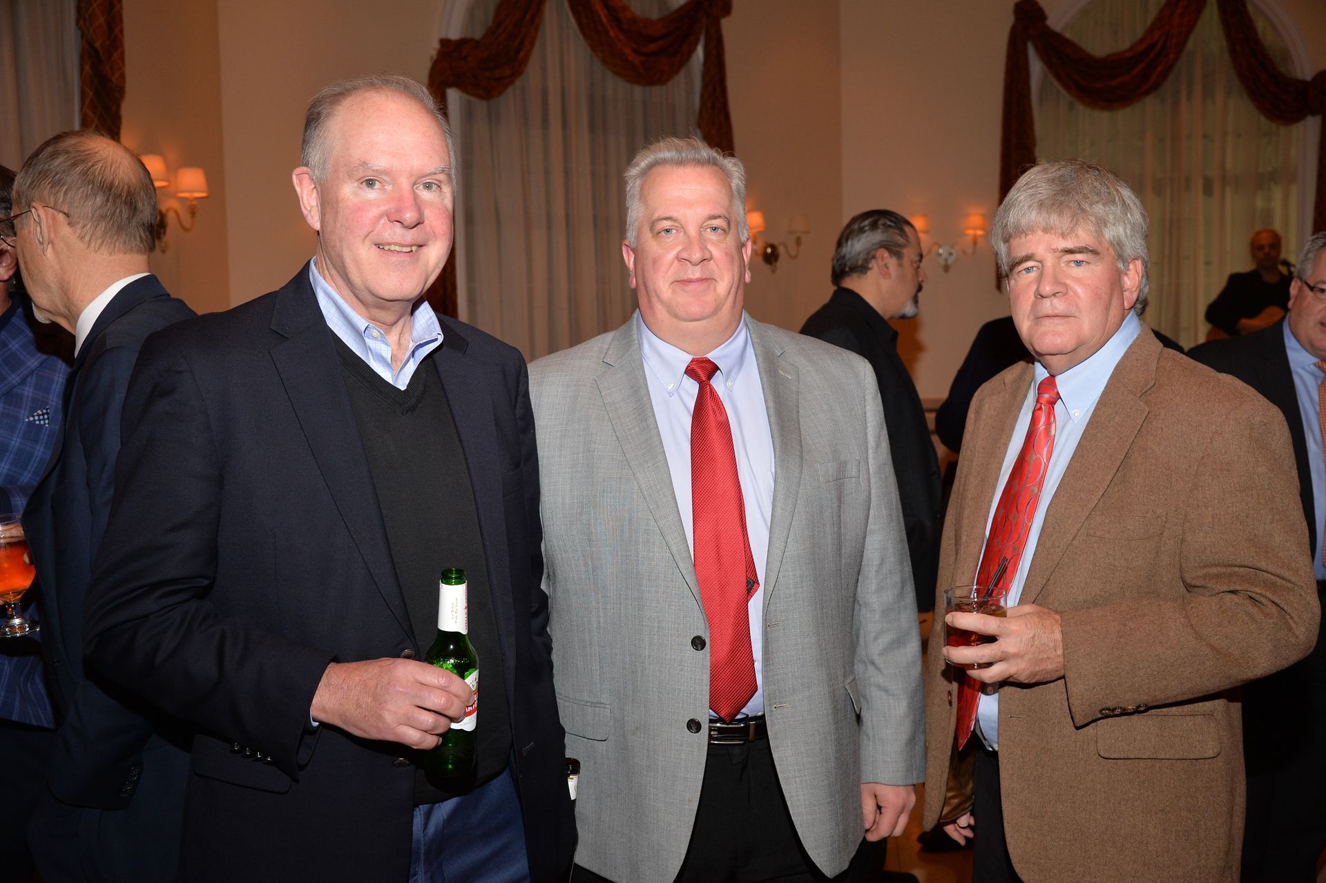 Three men in suits and ties are posing for a picture