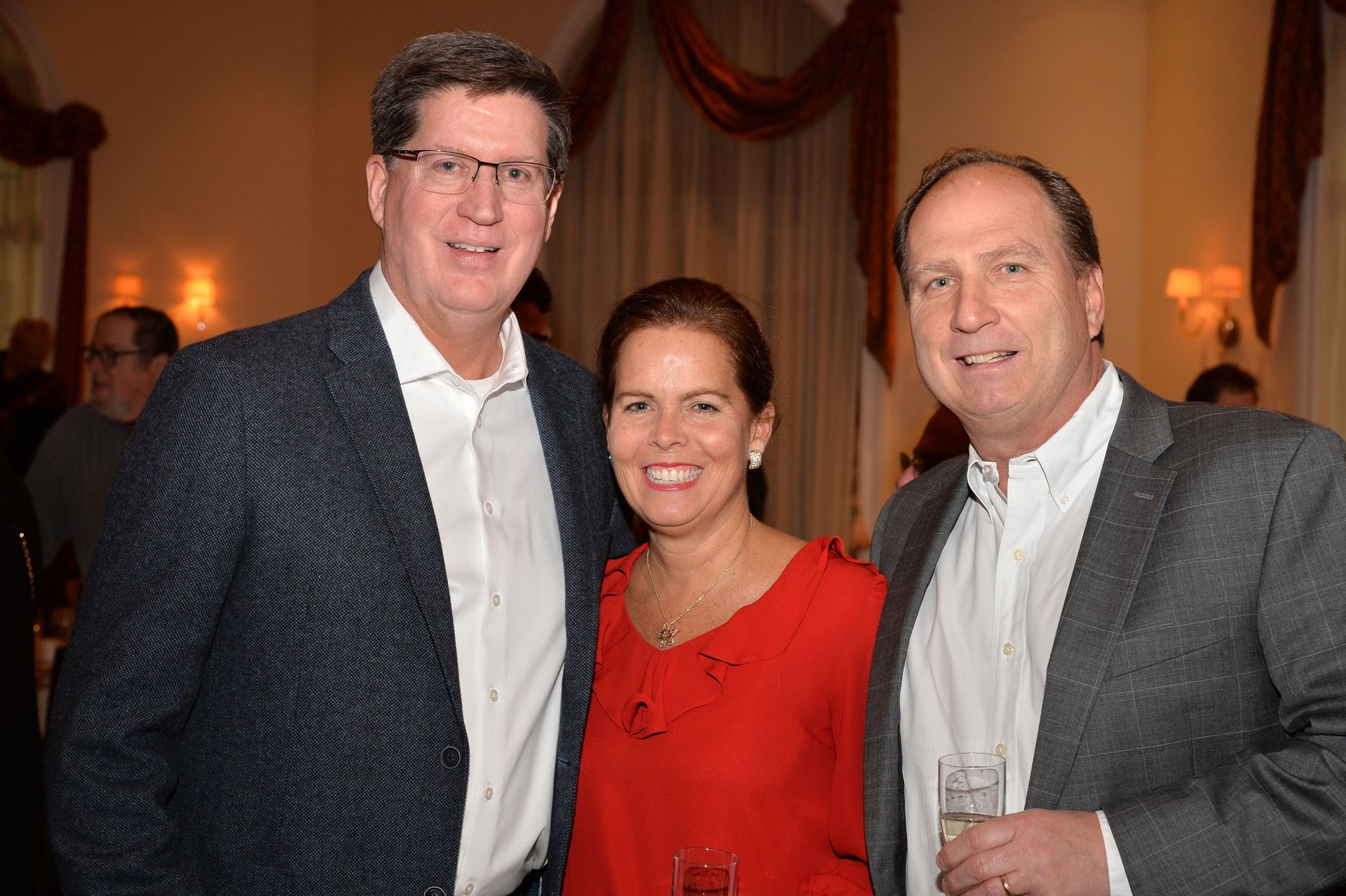 Three people are posing for a picture together in a room.