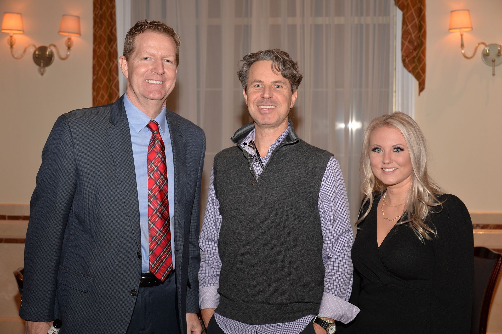 A man in a suit and tie is standing next to a woman in a black dress.