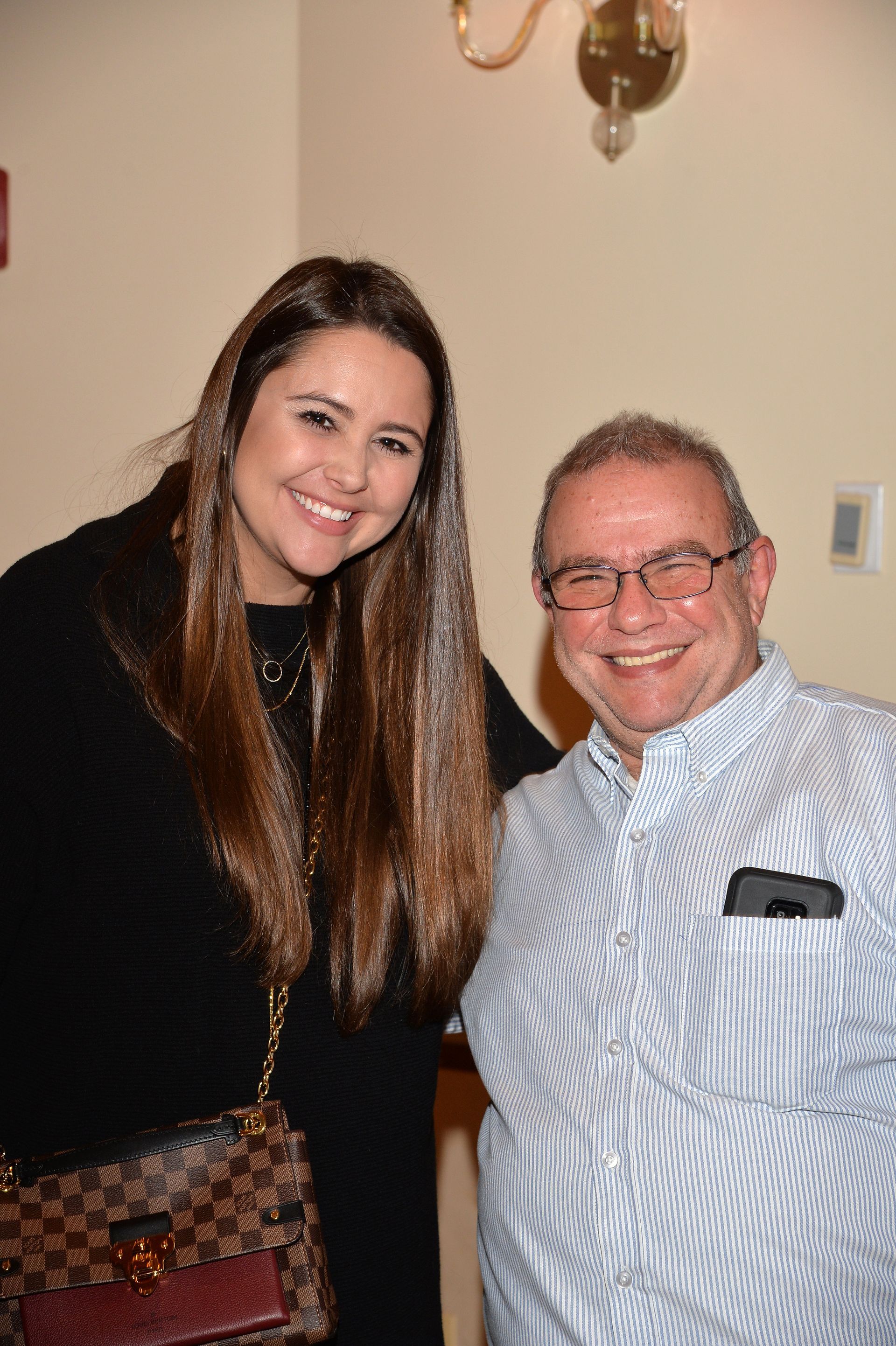 A man and a woman are posing for a picture together and smiling.