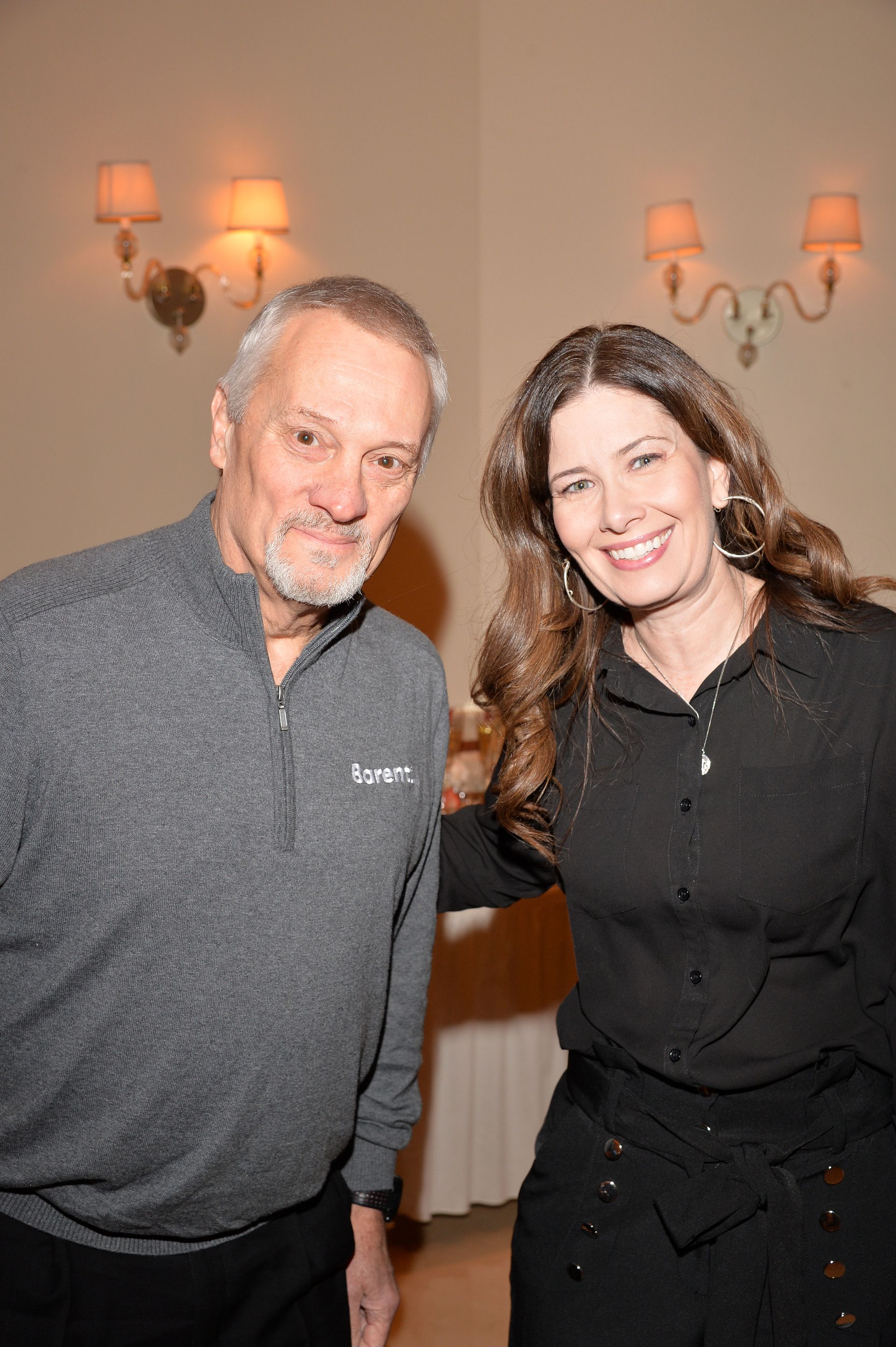 A man and a woman are posing for a picture in a room.