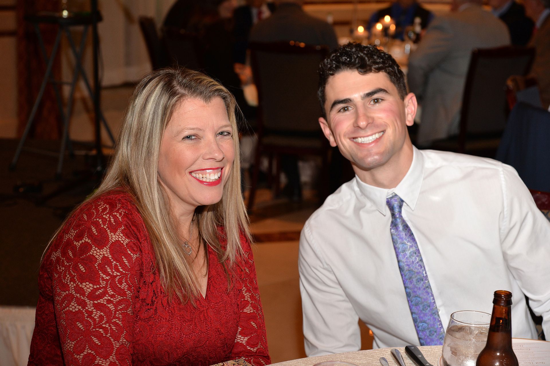 A man and a woman are posing for a picture while sitting at a table.