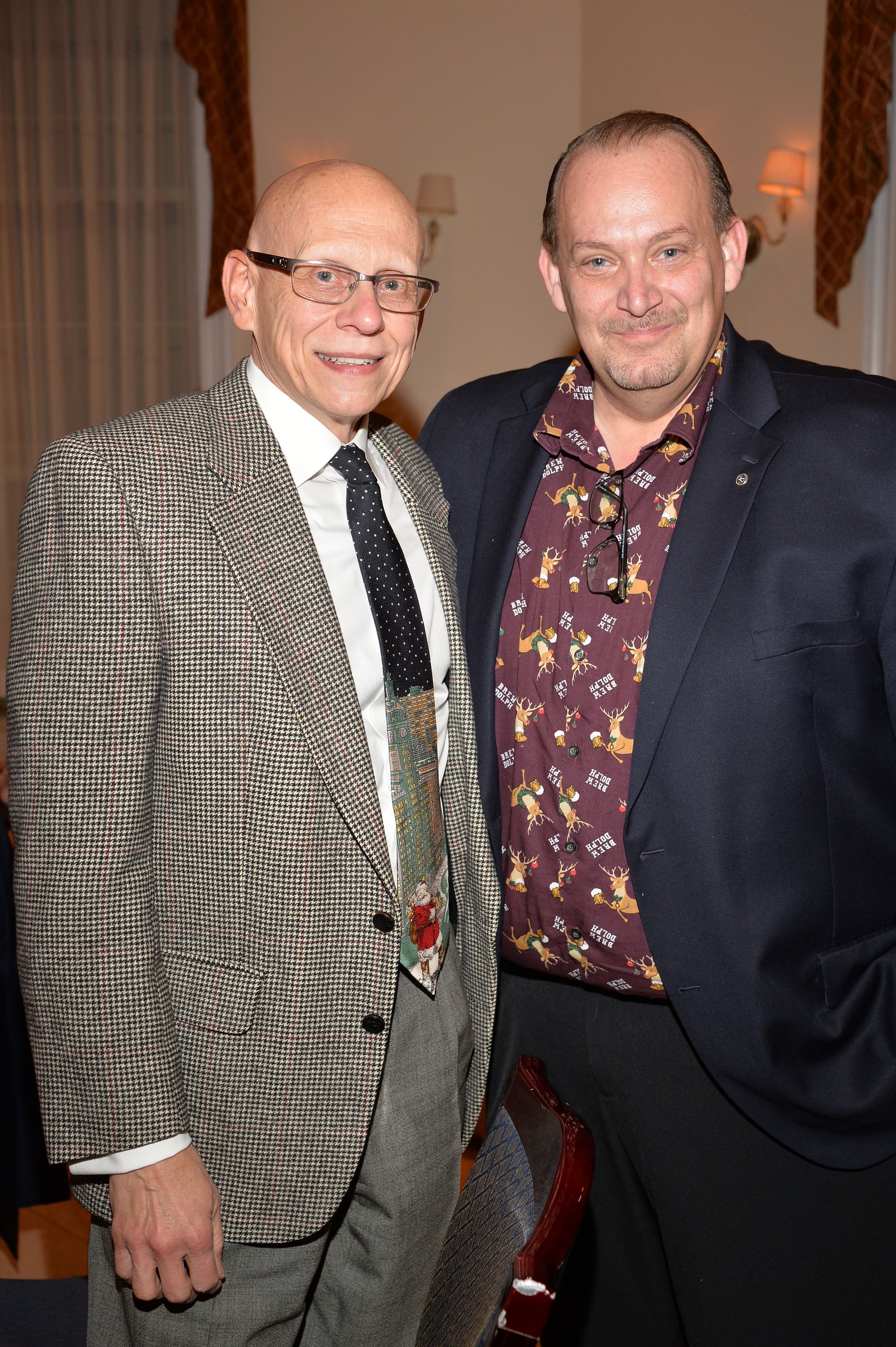 Two men in suits and ties are posing for a picture.