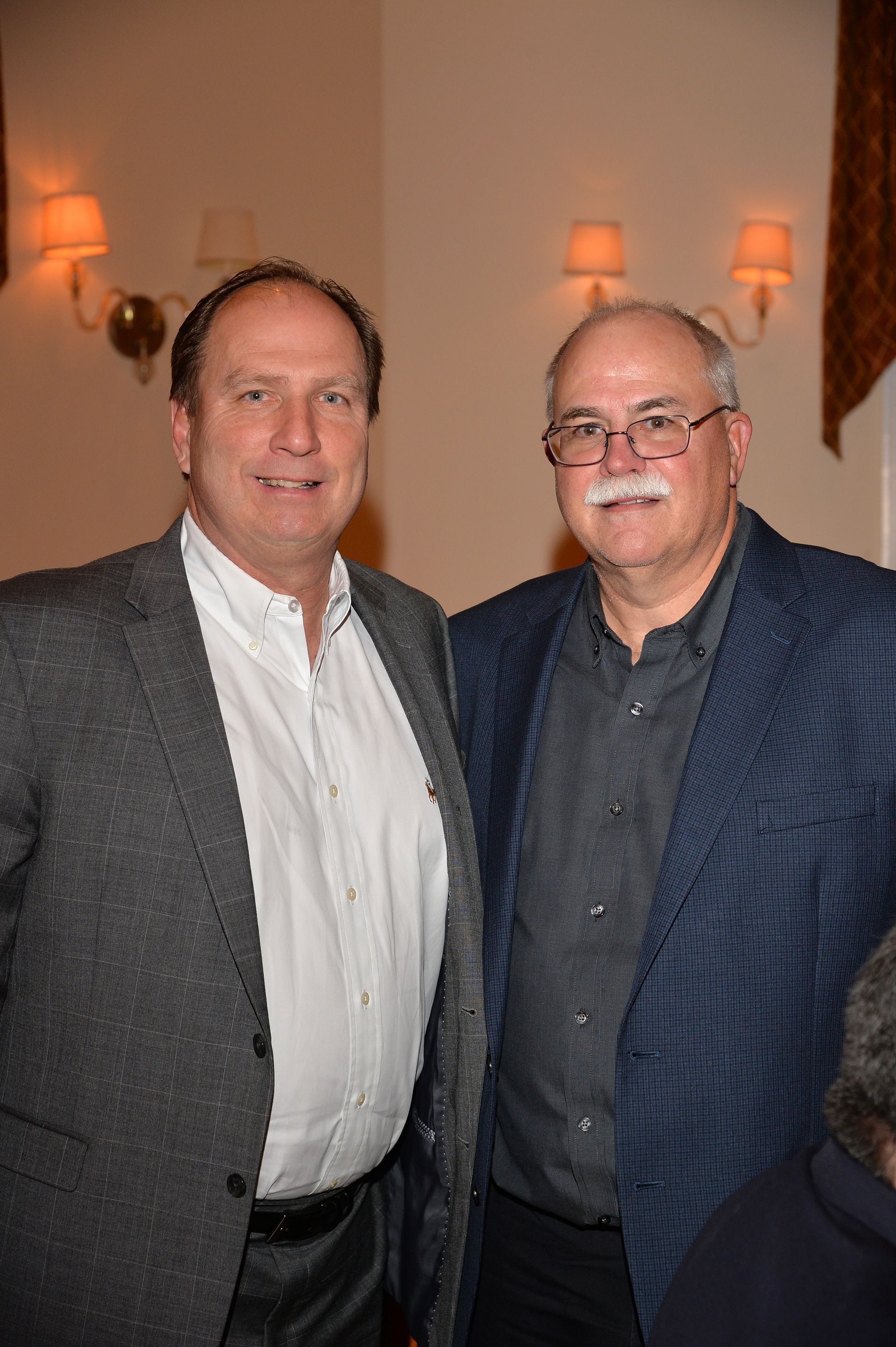 Two men are posing for a picture together in a room.