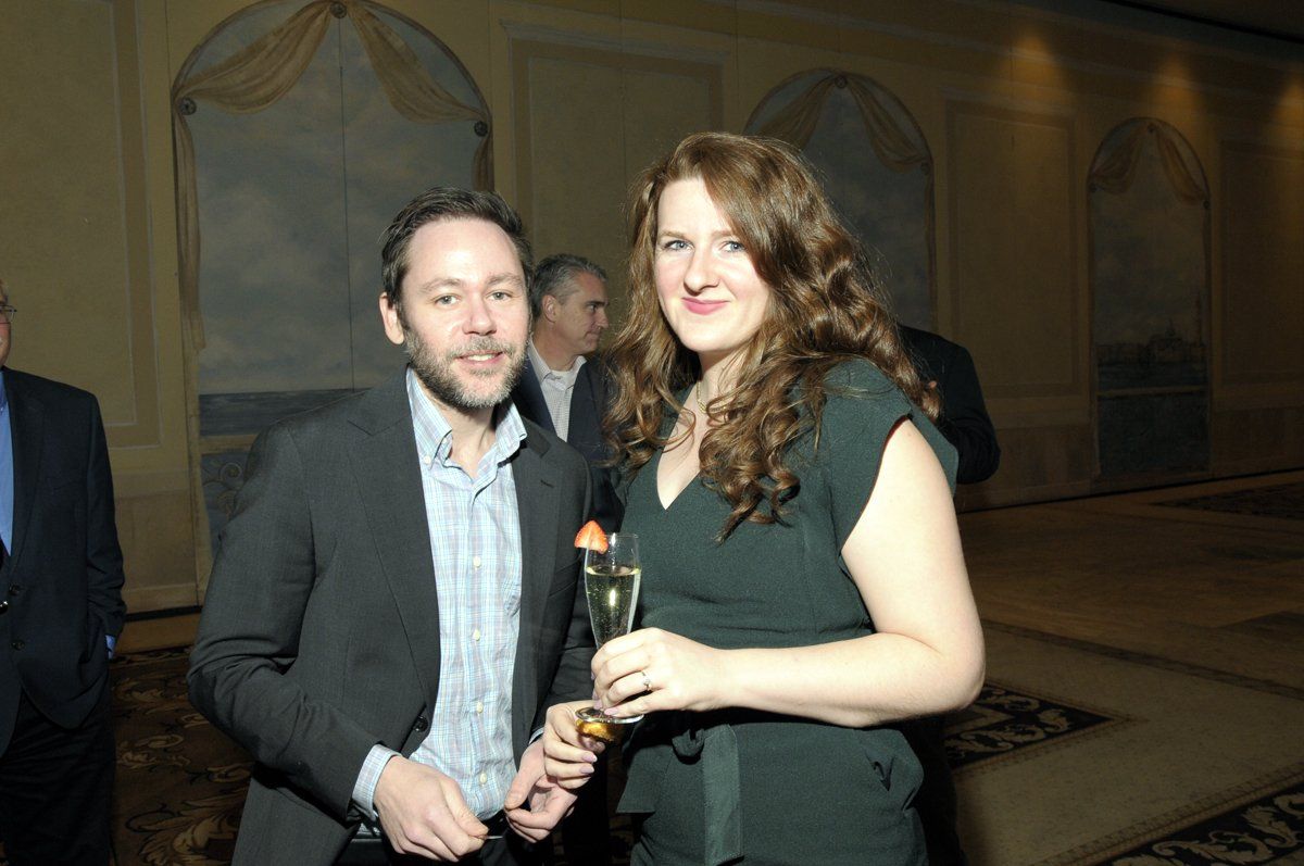 A man and a woman standing next to each other holding glasses of champagne