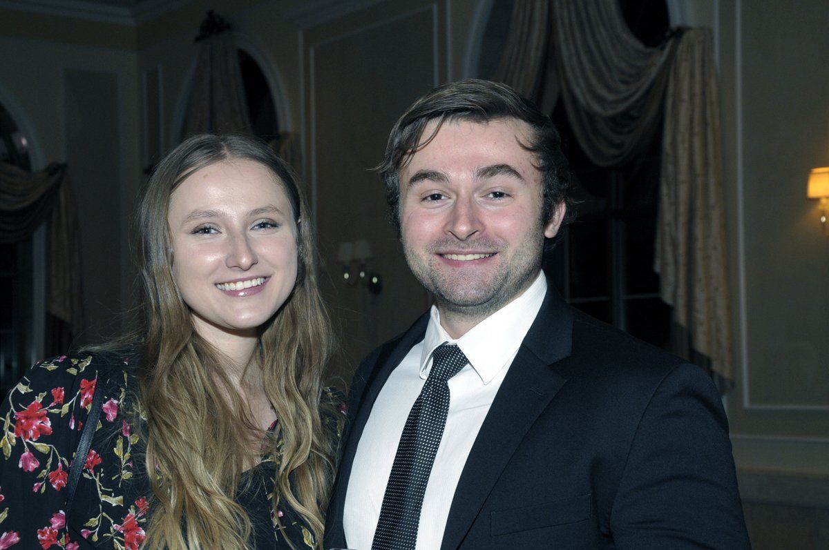 A man and a woman are posing for a picture in a room.