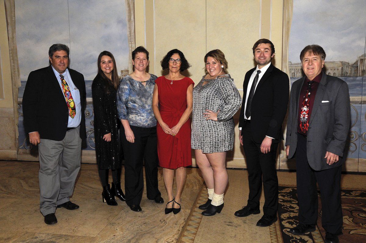 A group of people standing next to each other in a room.