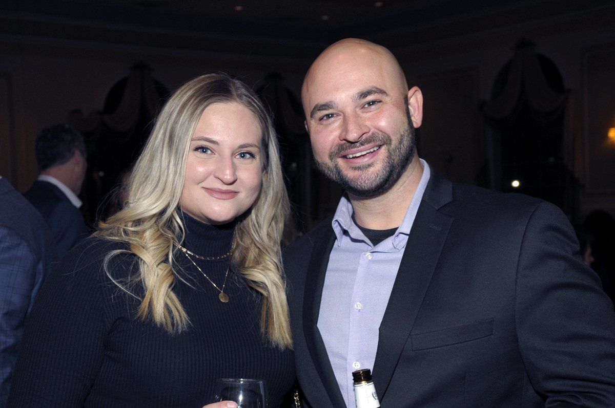 A man and a woman are posing for a picture at a party.