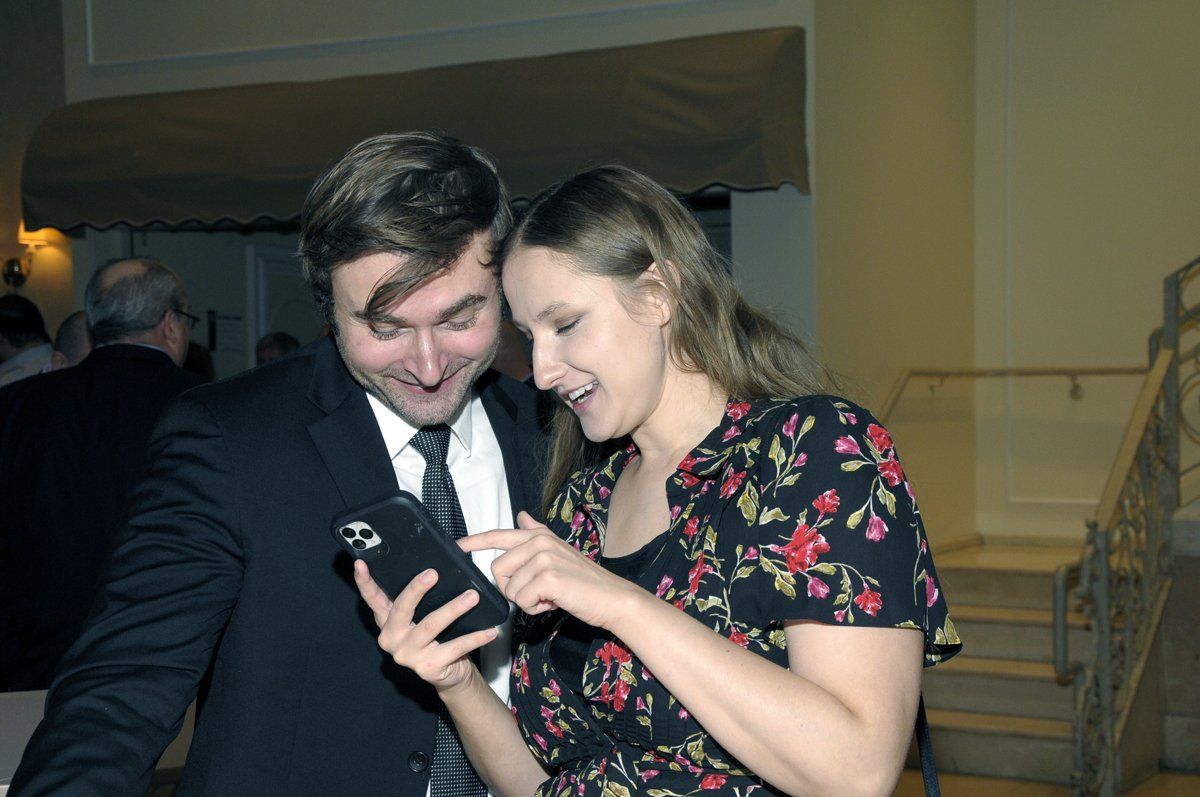 A man and a woman are looking at a cell phone together