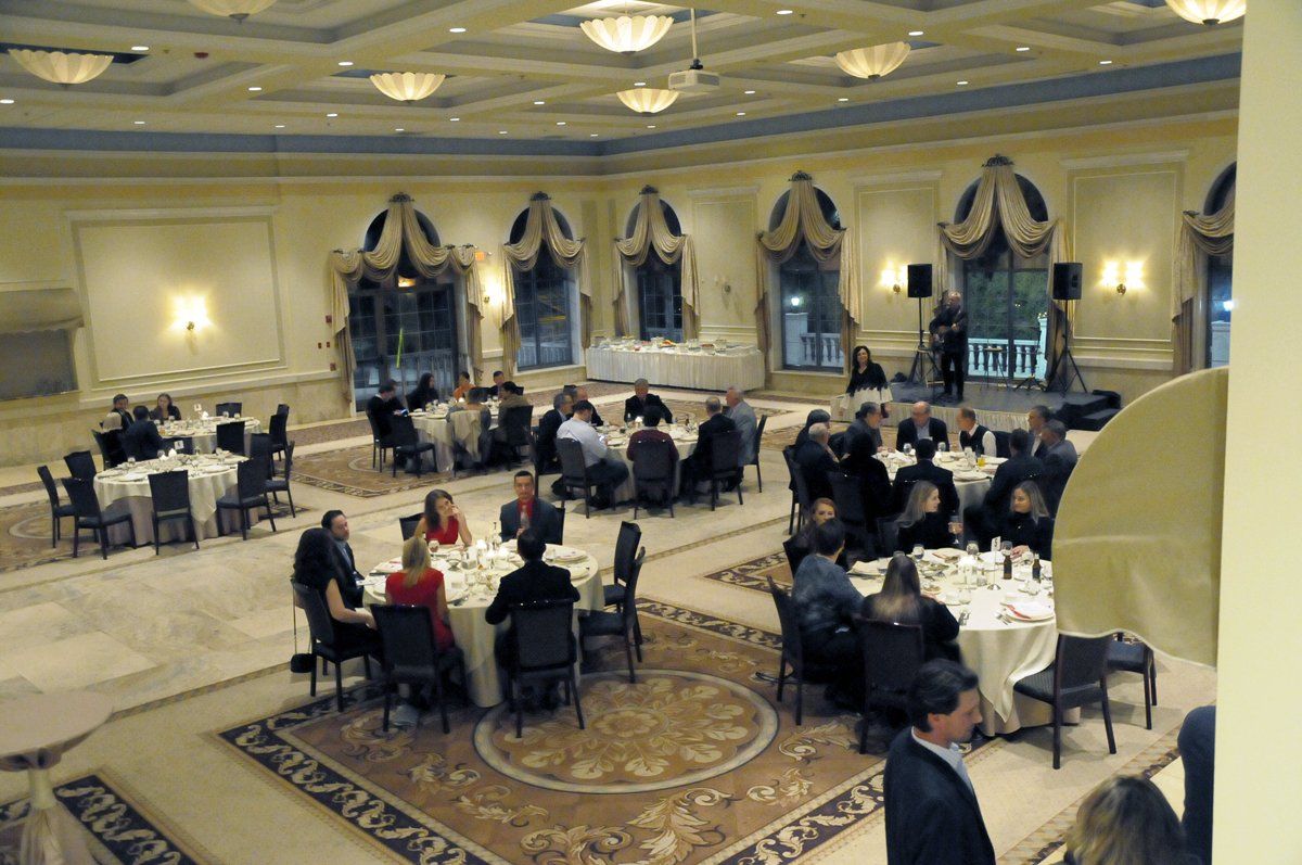 A group of people are sitting at tables in a large room