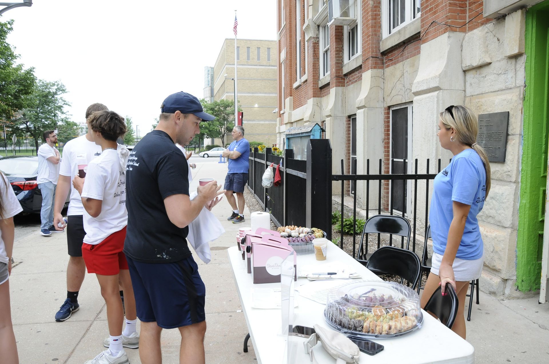 A group of people standing around a table with food on it