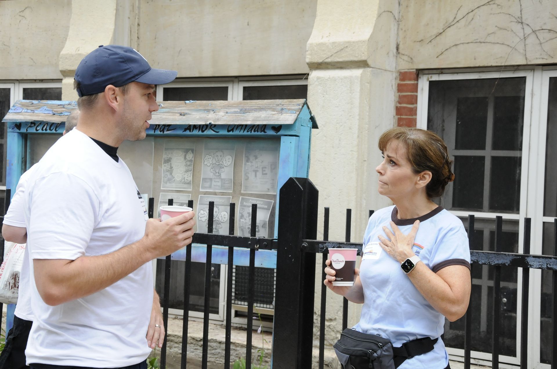 A man and a woman are standing next to each other talking