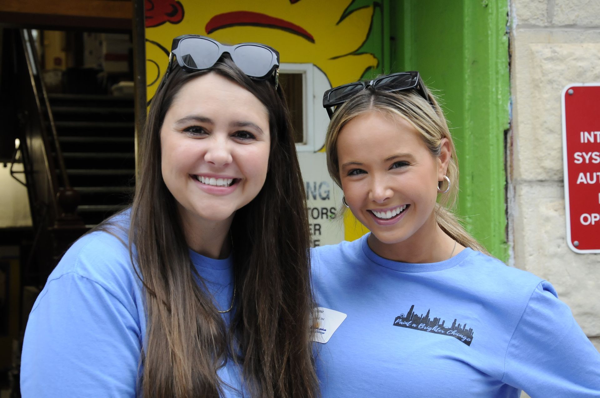 Two women are posing for a picture in front of a no parking sign