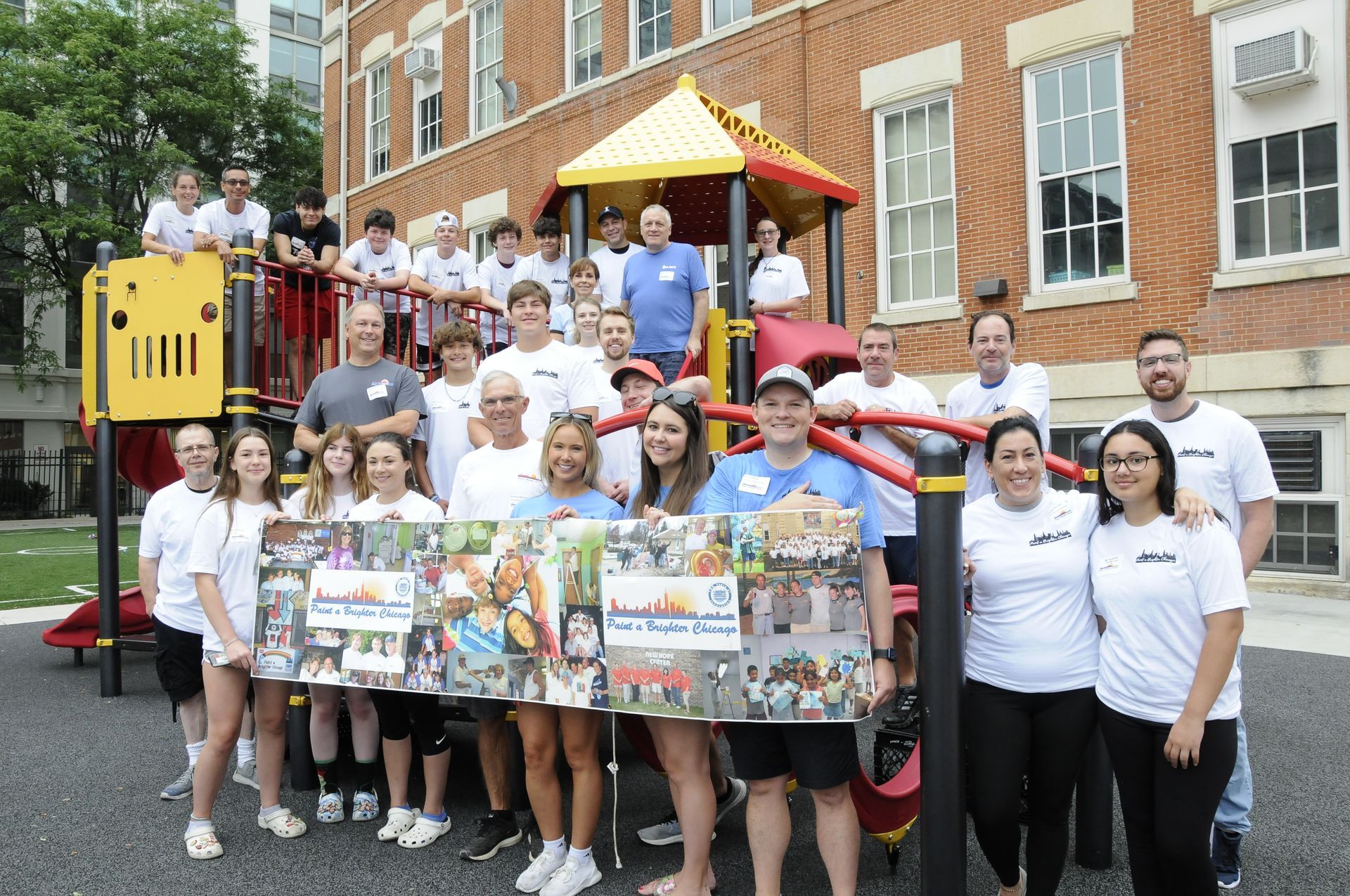 A group of people are posing for a picture in front of a playground.