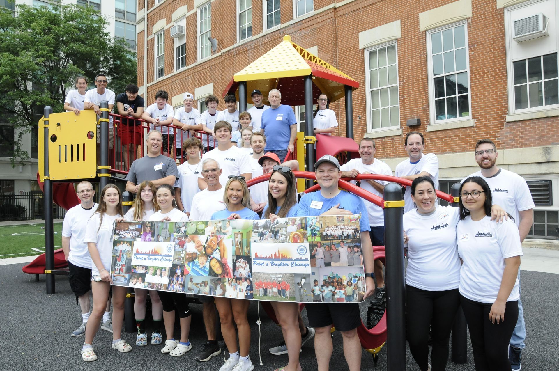 A group of people are posing for a picture in front of a playground.