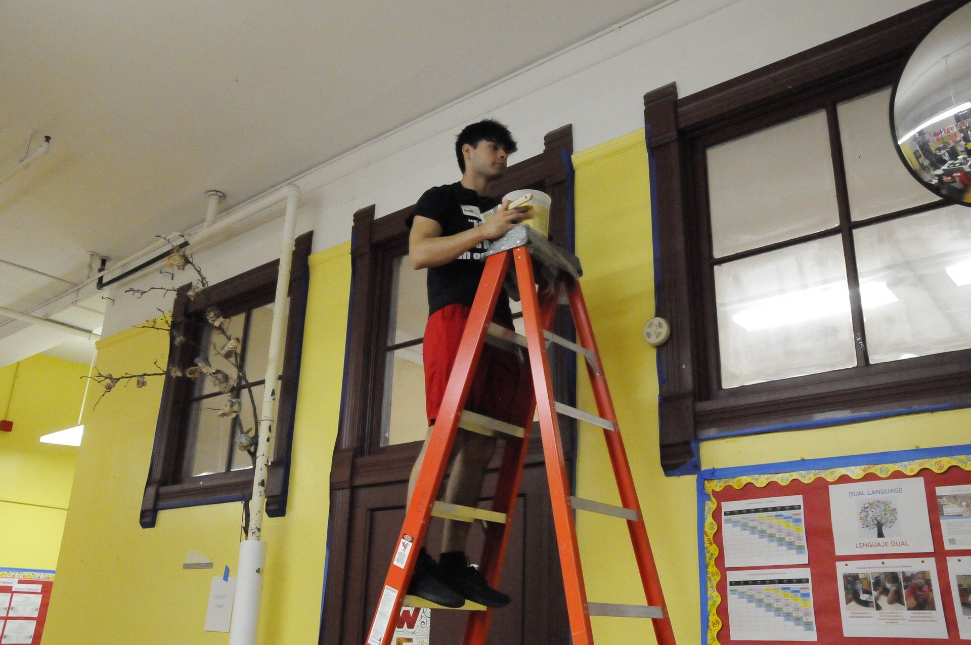 A man is standing on a ladder in front of a door