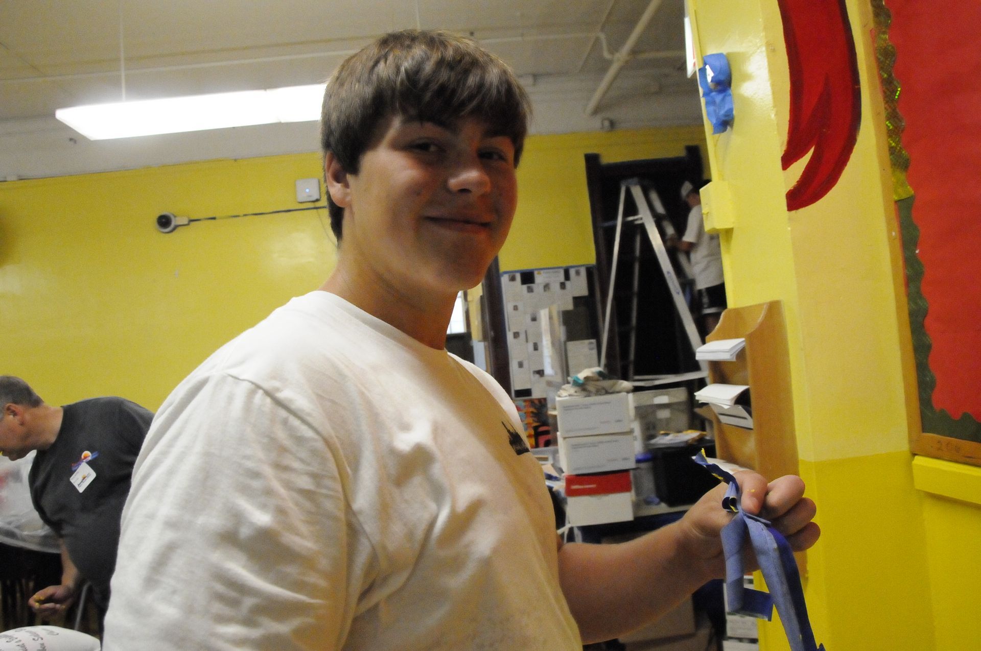 A young man in a white shirt is holding a blue leash