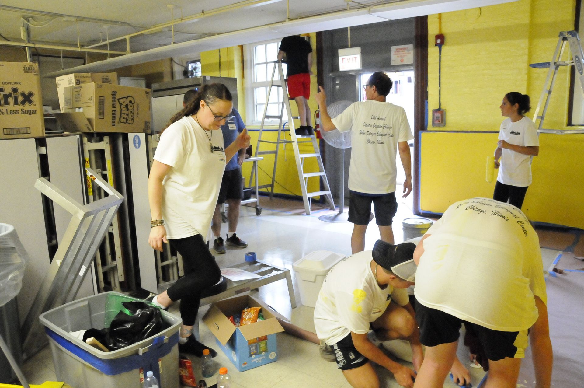 A group of people are working in a room with a box that says mix on it