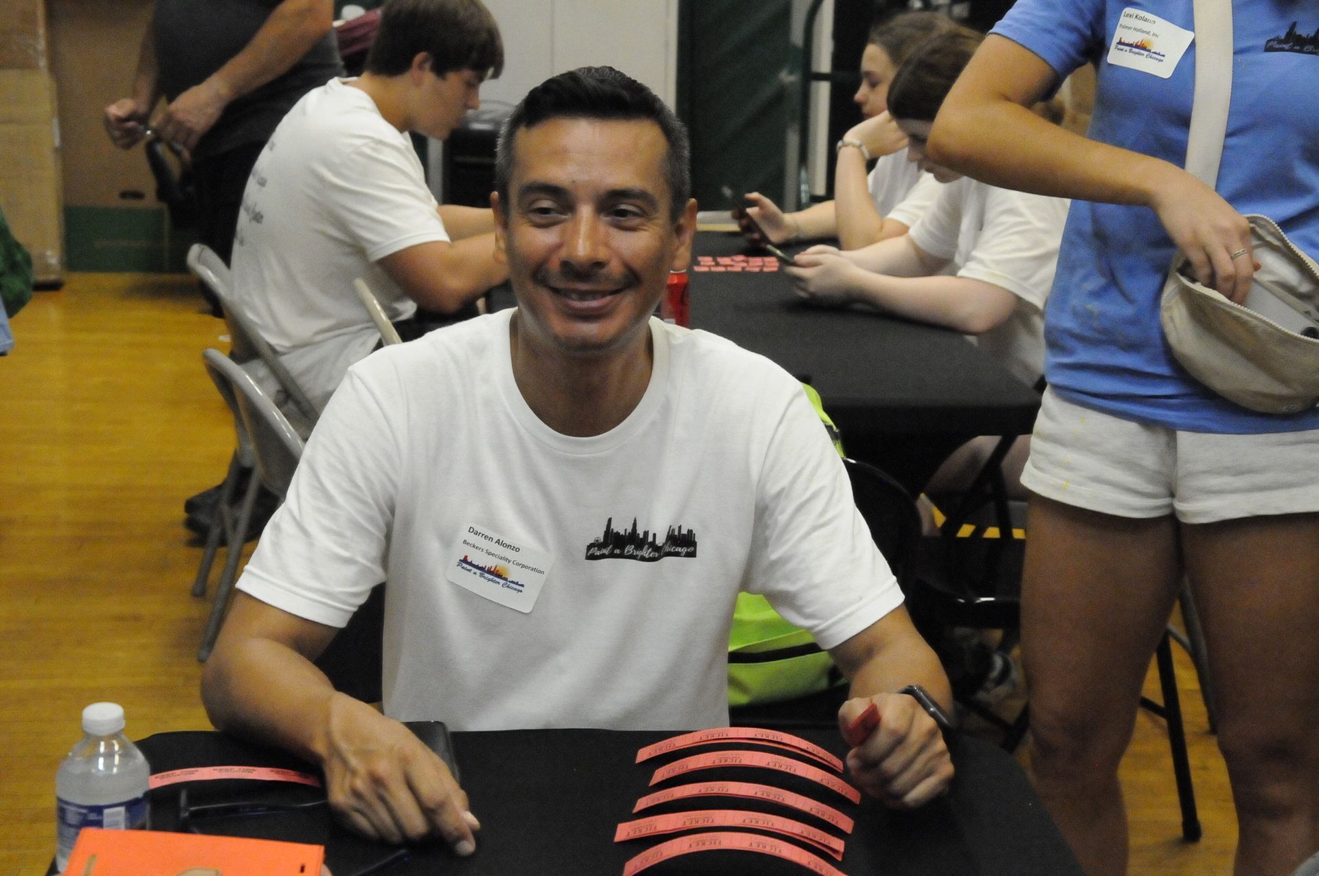 A man in a white shirt is smiling while sitting at a table