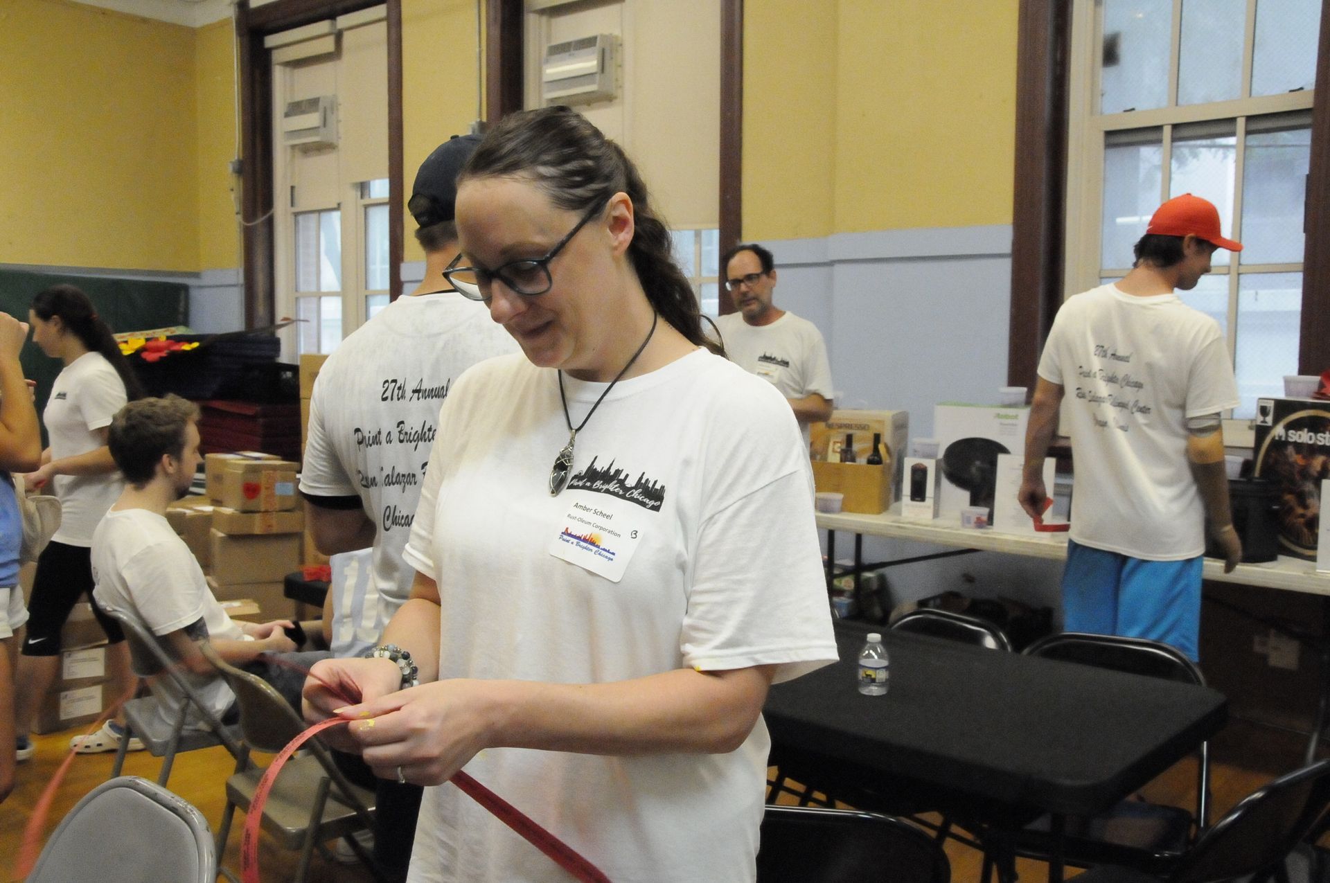 A woman in a white shirt has a name tag on her neck